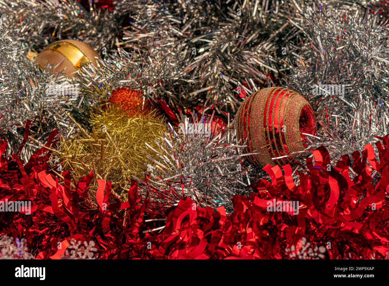 Festive Christmas decorations with colorful tinsel and glittering baubles Stock Photo