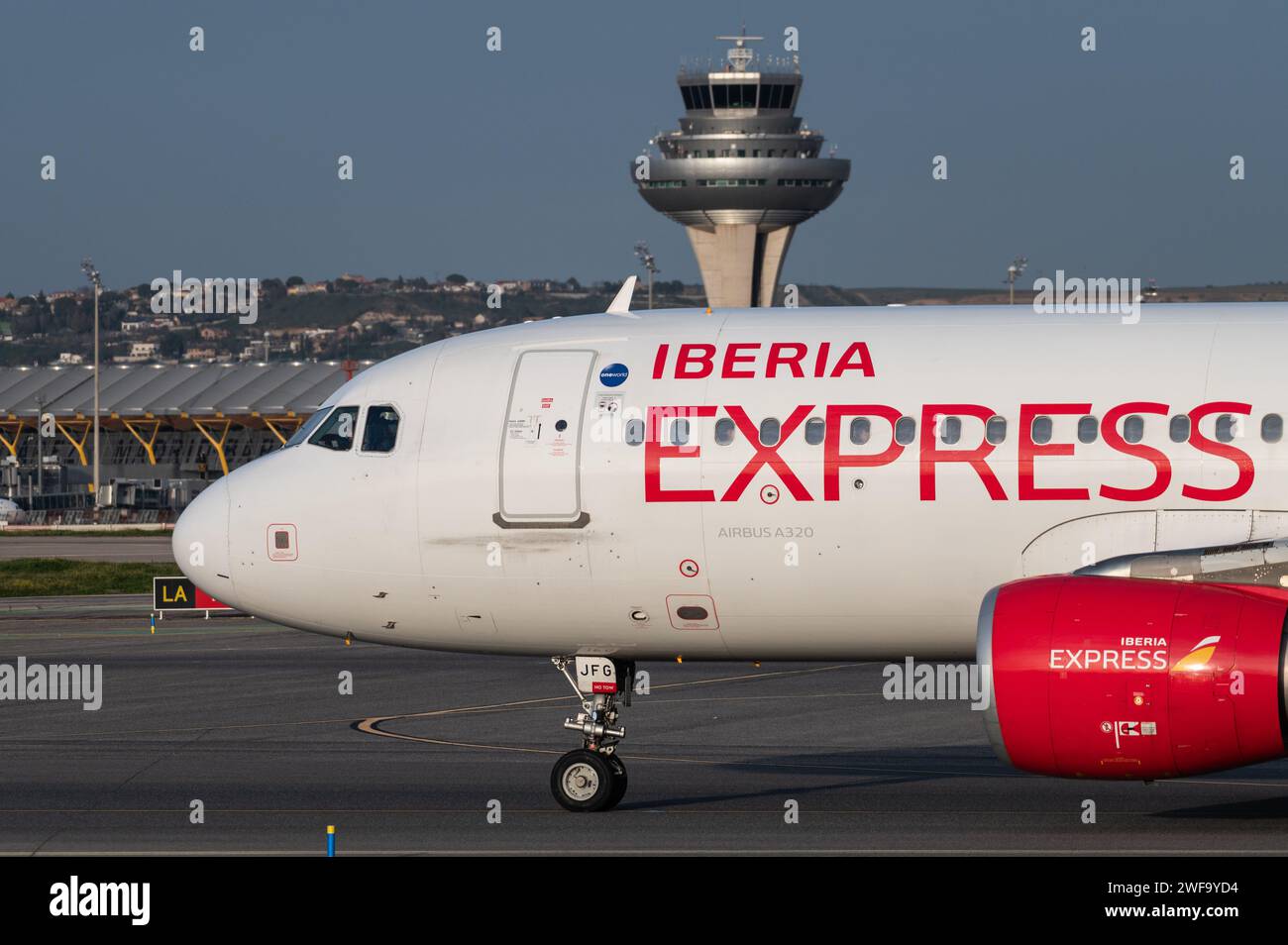 Madrid, Spain. 29th Jan, 2024. A passenger flight of Iberia Express in a runway at Adolfo Suarez Madrid-Barajas Airport passing by the control tower. The President of the Government of Spain, Pedro Sanchez, announced the launch of the expansion of the Adolfo Suarez Madrid-Barajas airport, which will be the largest investment in airport infrastructure in the last decade with 2,400 million euros. Credit: Marcos del Mazo/Alamy Live News Stock Photo