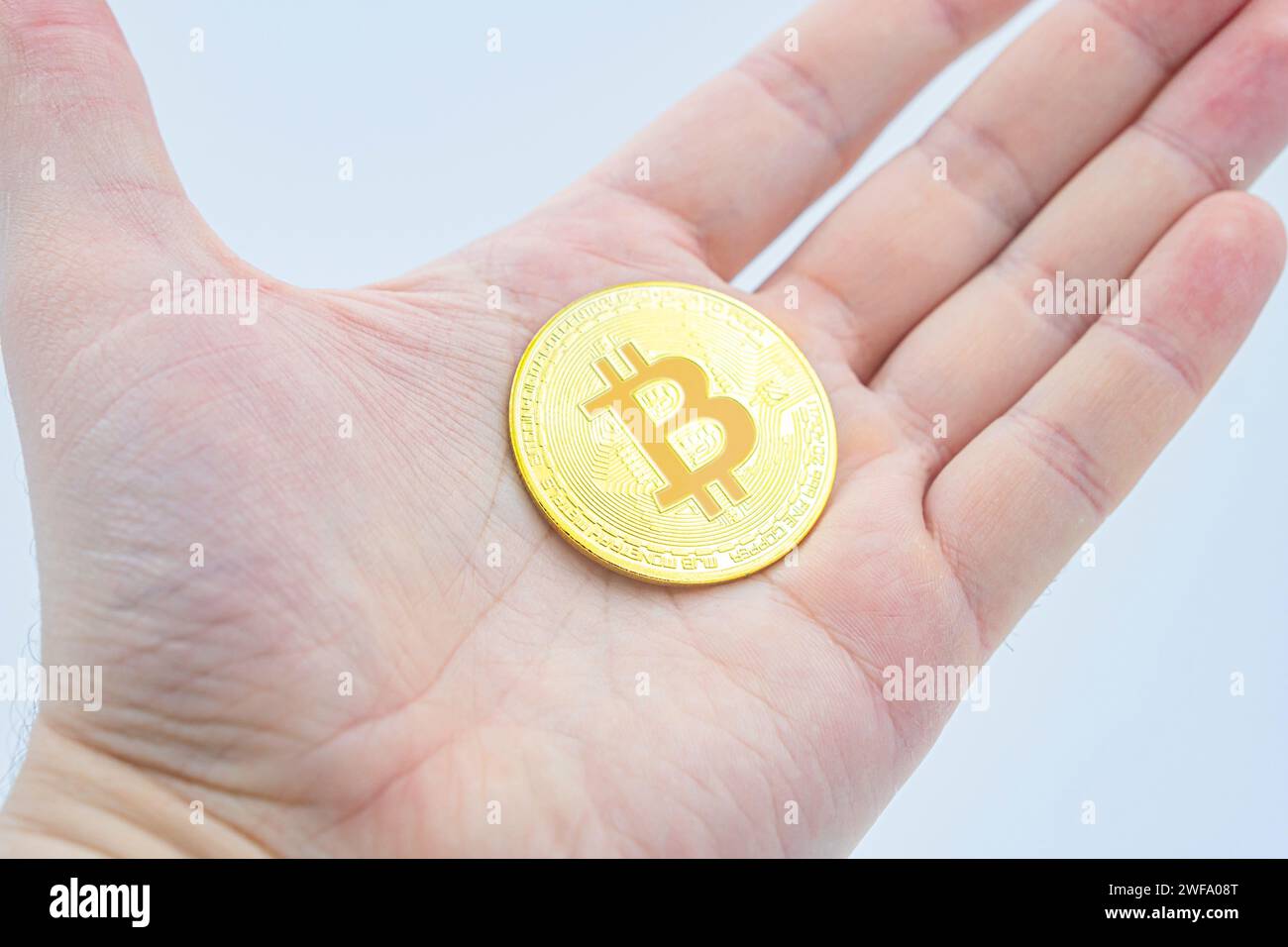 Open palm handful of bitcoins as a concept of openness to new technologies and cryptocurrencies as well as investing in mining and halving. Holding Bi Stock Photo