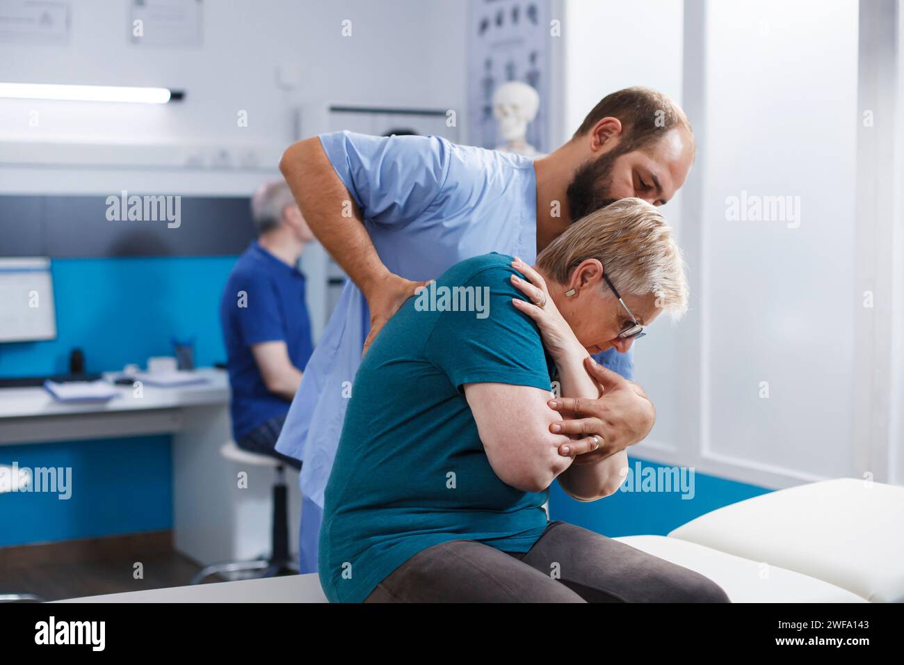 Osteopathic doctor cracking back and shoulder bones for retired old