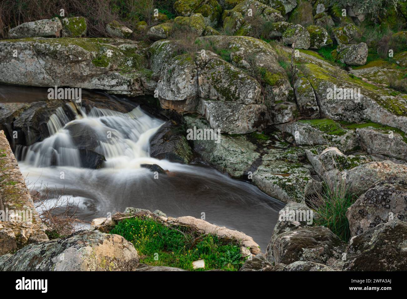 Waterfall formed by the Salor river, at its entrance to the El Gallo reservoir, in Extremadura, Spain. Long exposure photography Stock Photo