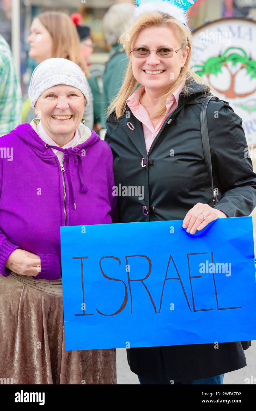 United in celebration: Two women proudly holding an Israel sign, adding their radiant spirit to the Festival of Nations in Panama City, Florida USA Stock Photo