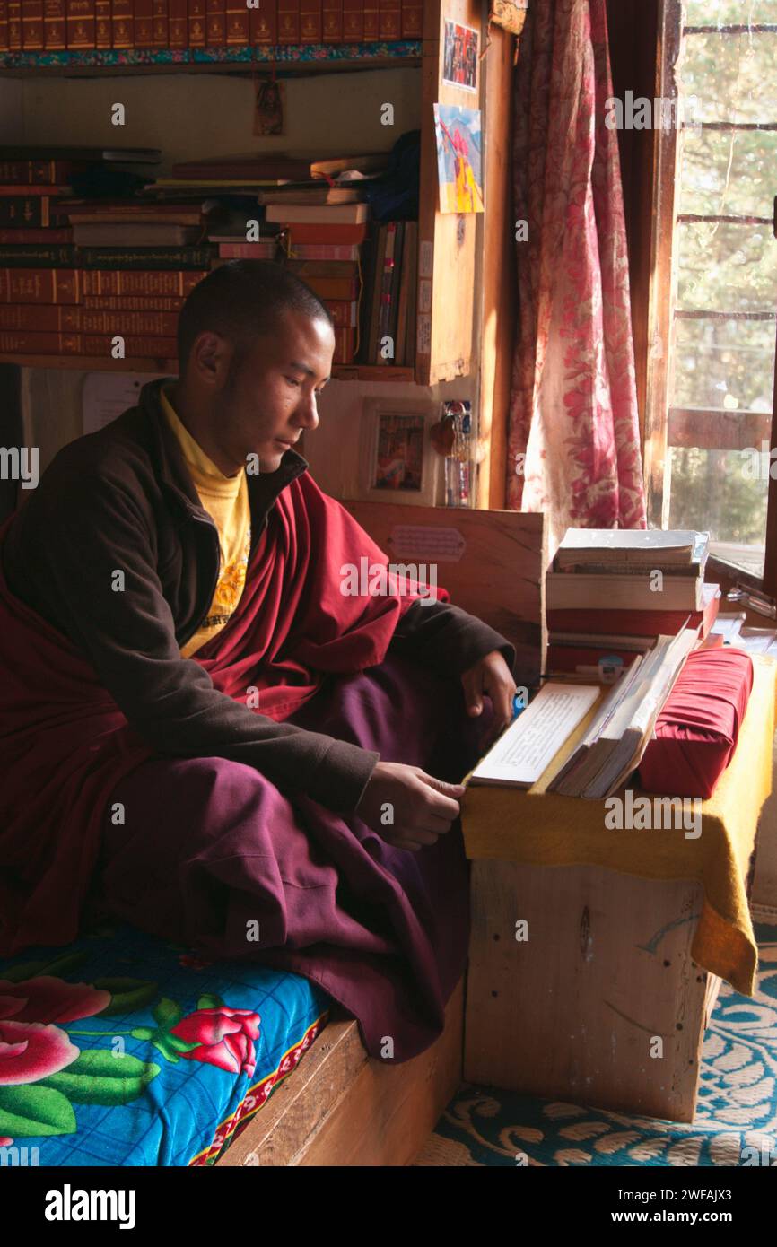 Young monk in his dorm room studies Buddhist scripts at school, Phobjikha Valley, central Bhutan, Asia Stock Photo