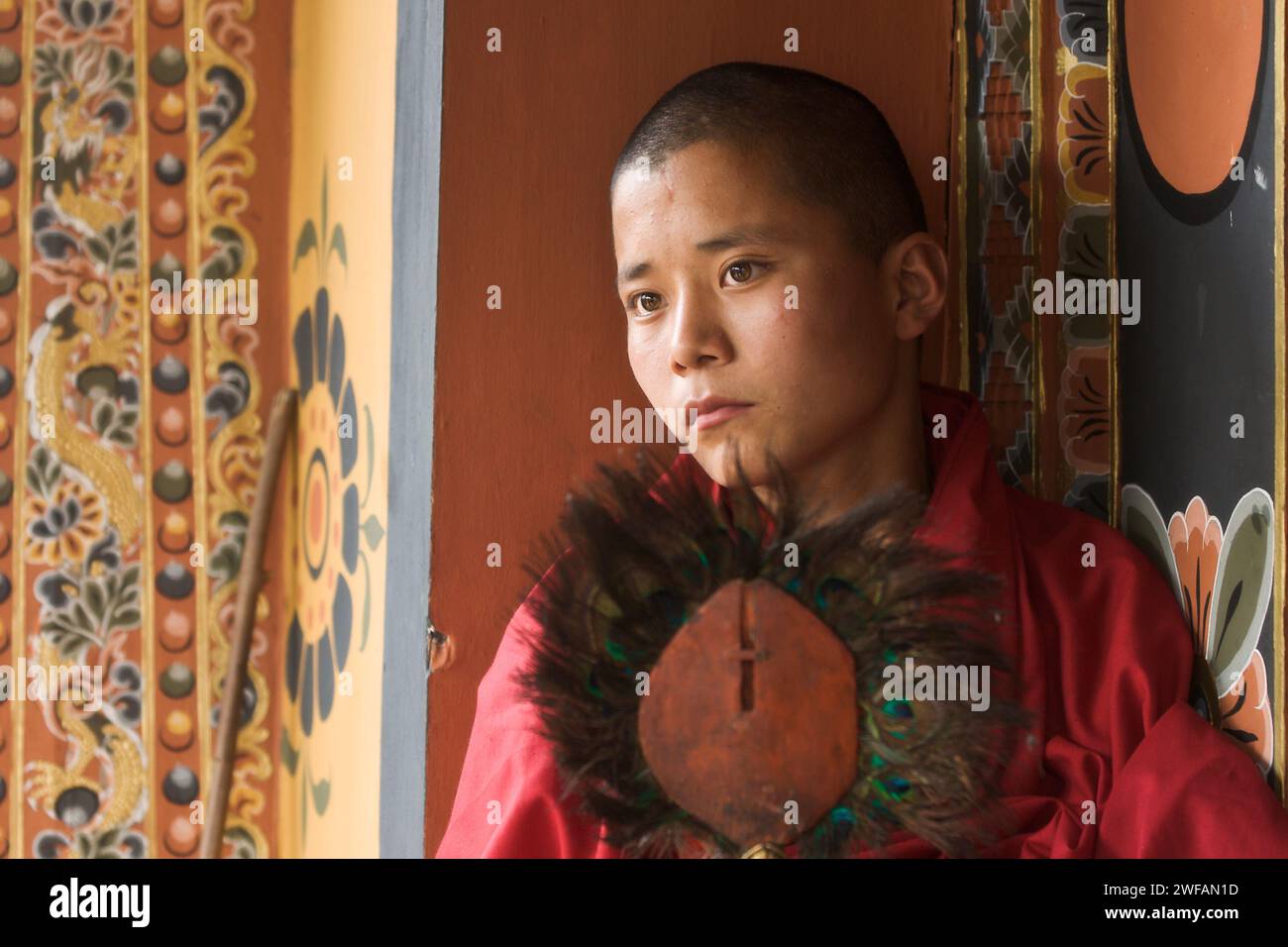 A monk holds a peacock feathered religious instrument inside the Punakha Dzong fortress temple monastery where the 1st King of Bhutan was crowned Stock Photo