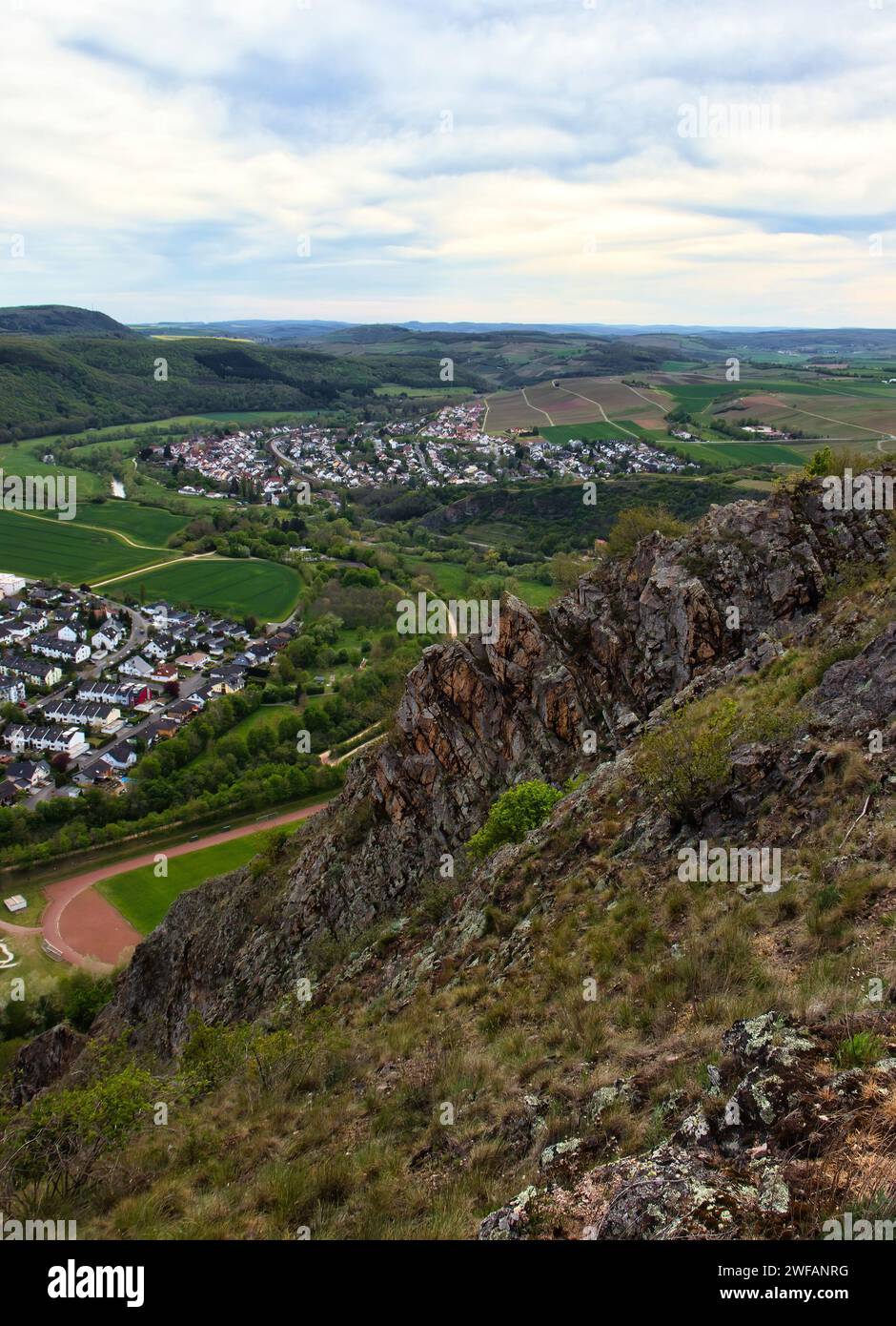 Bad Munster, Germany - May 9, 2021: Side of Rotenfels cliff overlooking German towns surrounded by green fields and hills on a sprint day. Stock Photo