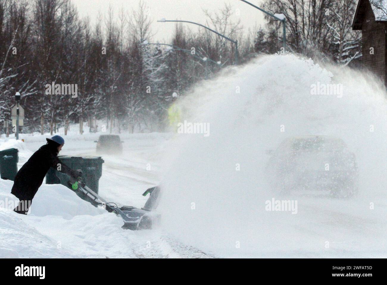 A resident uses a snowblower to clear a driveway, Monday, Jan. 29, 2024