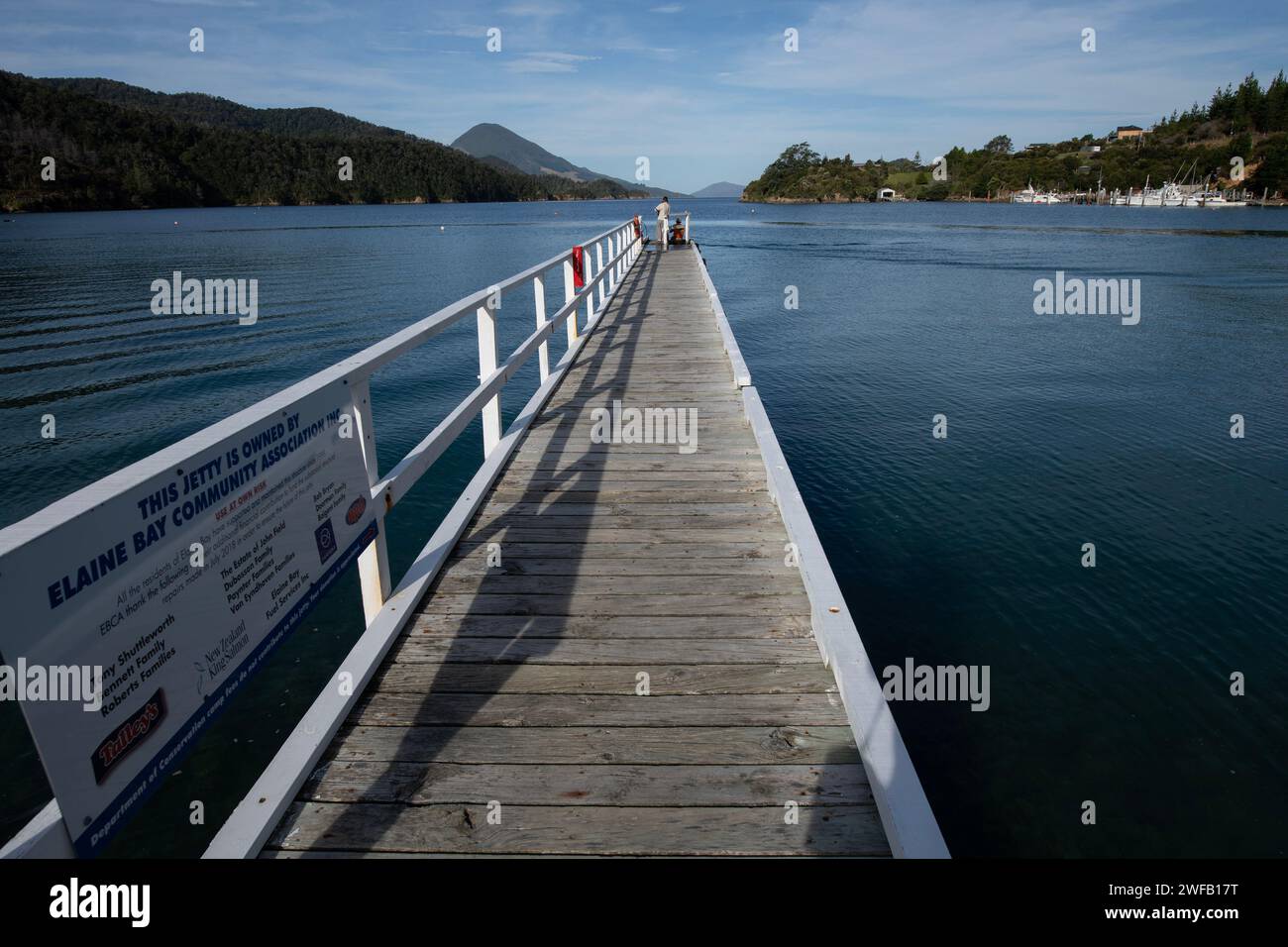 Jetty with sign and people fishing, Elaine Bay, Pelorus Sound
