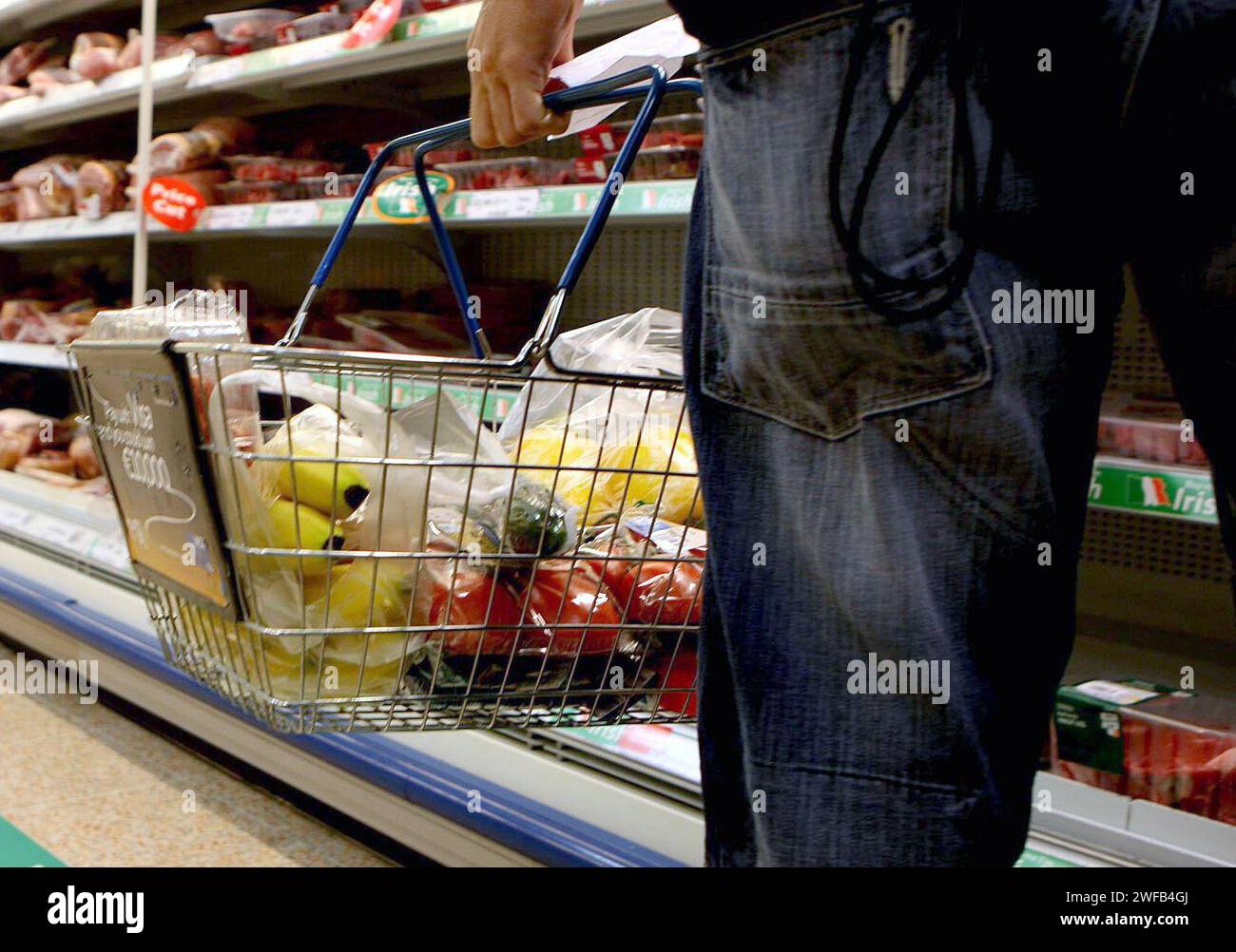 Undated file photo of a person holding a shopping basket in a supermarket. Shop price inflation fell in January to its lowest rate since May 2022 as retailers offered heavy discounts to entice customers, figures show. January's shop prices eased to 2.9% higher than a year ago, down from 4.3% in December and below the three-month average of 3.9%, according to the British Retail Consortium (BRC)-NielsenIQ Shop Price Index. Issue date: Tuesday January 30, 2024. Stock Photo