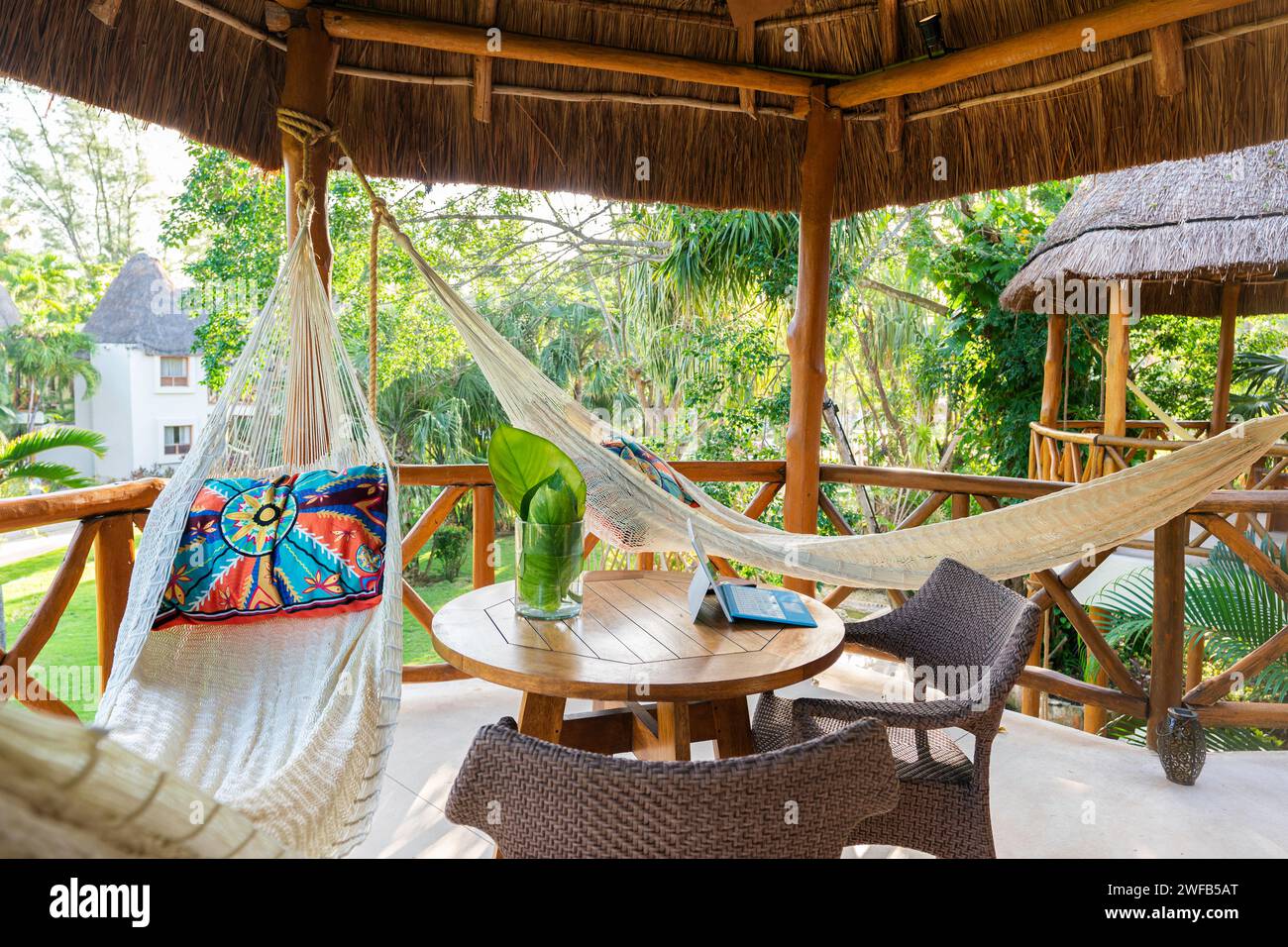 Balcony with hammocks and decorative pillows under a thatched hut at a tropical resort, Playa del Carmen, Mexico Stock Photo