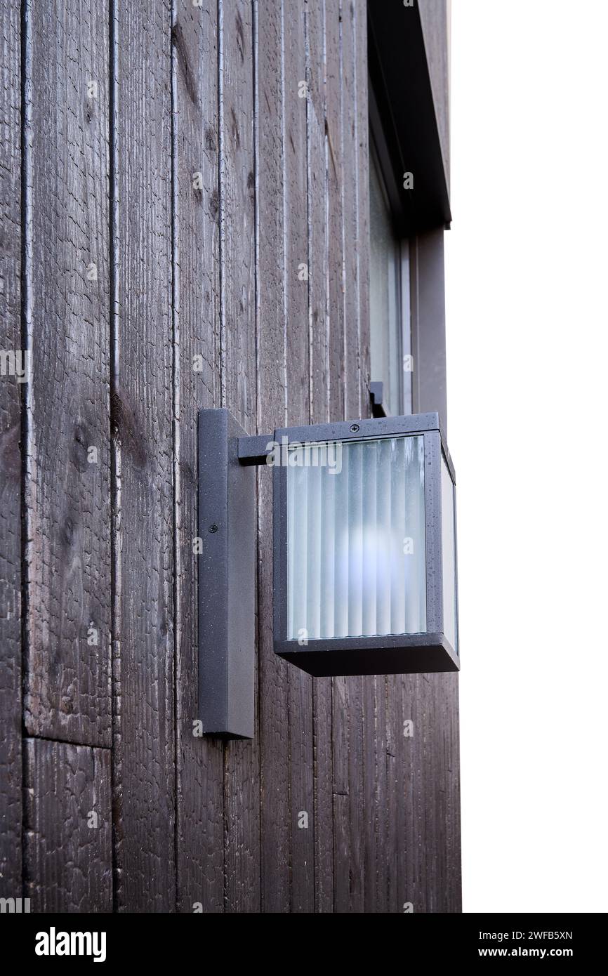 Modern external lamp on burned wood wall Stock Photo