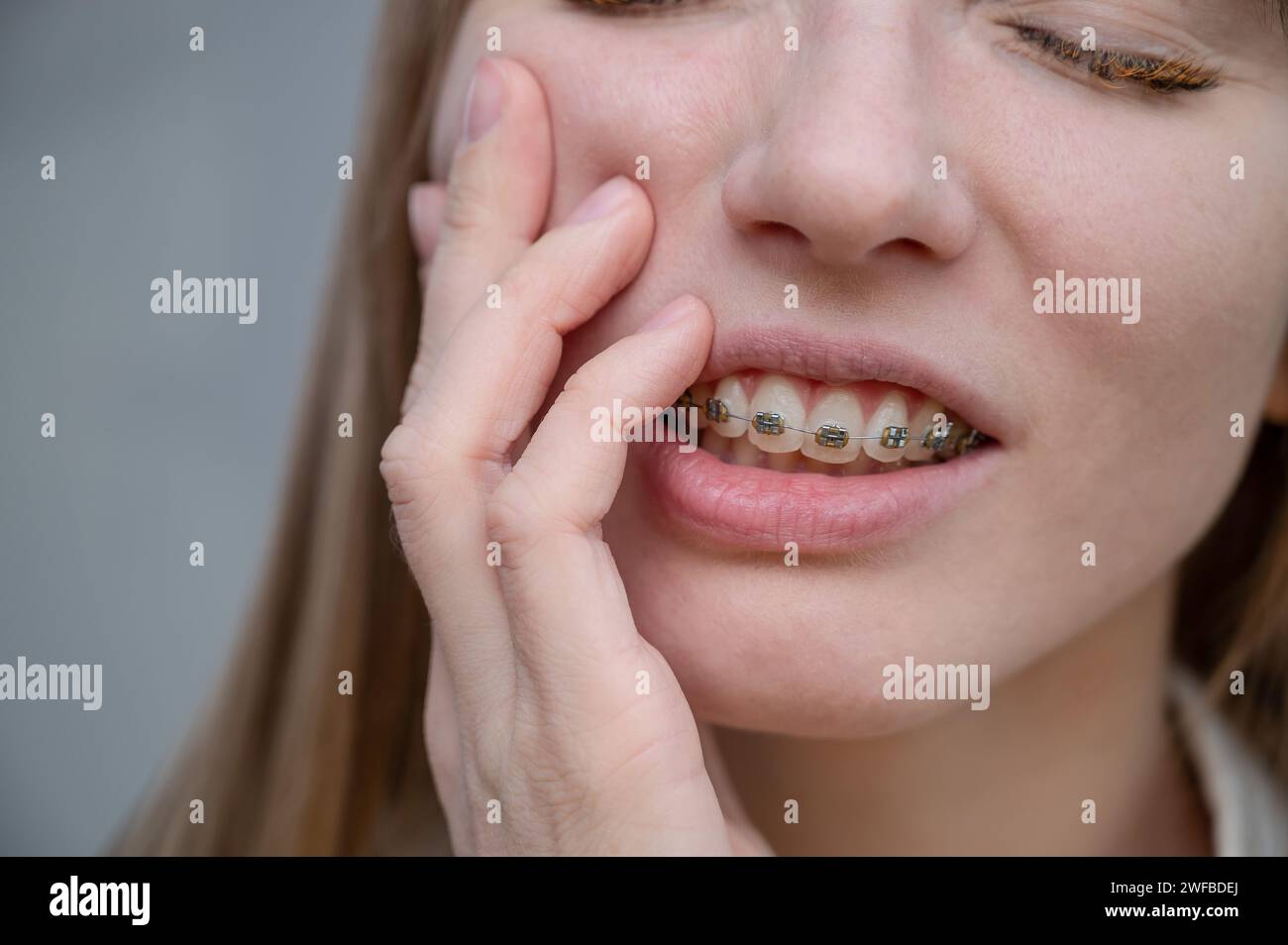 Closeup portrait of a redhaired girl suffering from pain due to