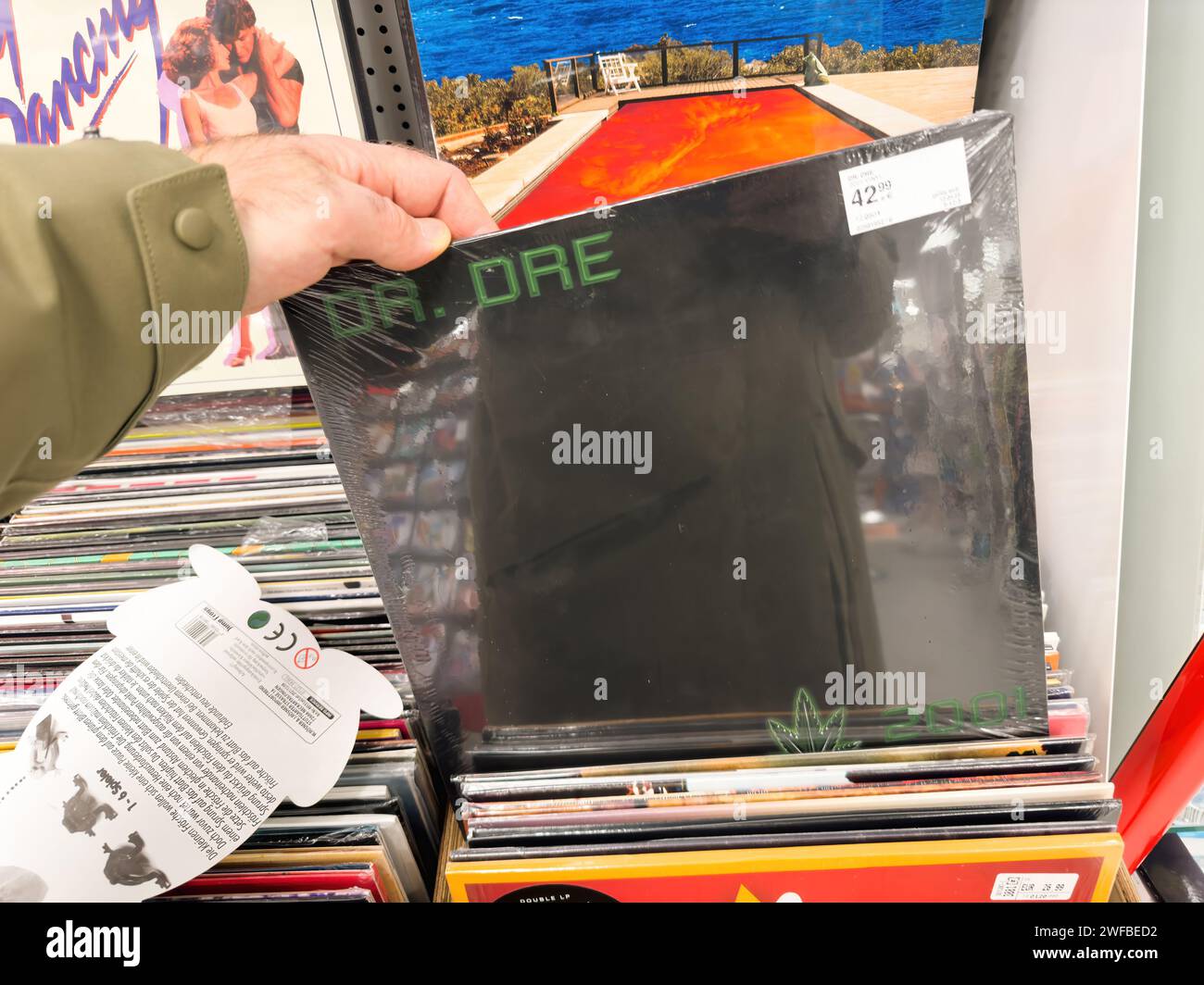 Berlin, Germany - Jan 18, 2024: A POV shot of a male hand shopping for a Dr. Dre music LP vinyl in an iconic album store inside the music store. Stock Photo