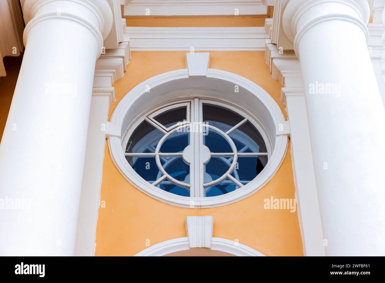 Classic architecture details, round window with white frame in yellow stone wall Stock Photo