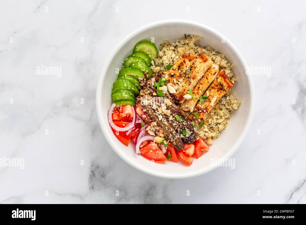 Healthy bowl with cauliflower rice, enoki mushrooms, chicken and vegetables. Keto/Paleo diet
