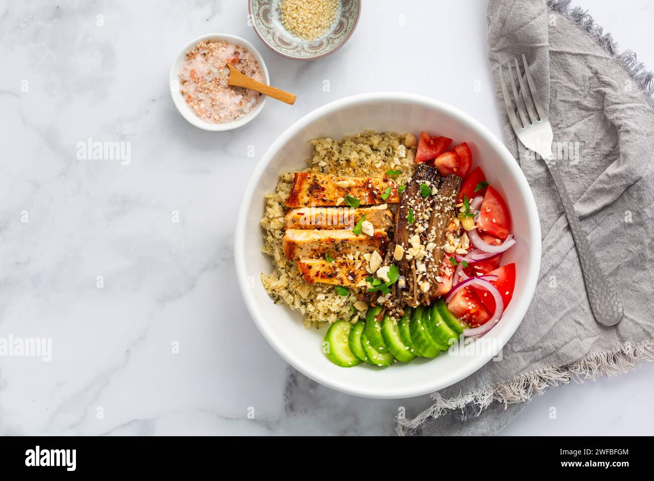 Healthy bowl with cauliflower rice, enoki mushrooms, chicken and vegetables. Keto/Paleo diet menu, low carb. Stock Photo