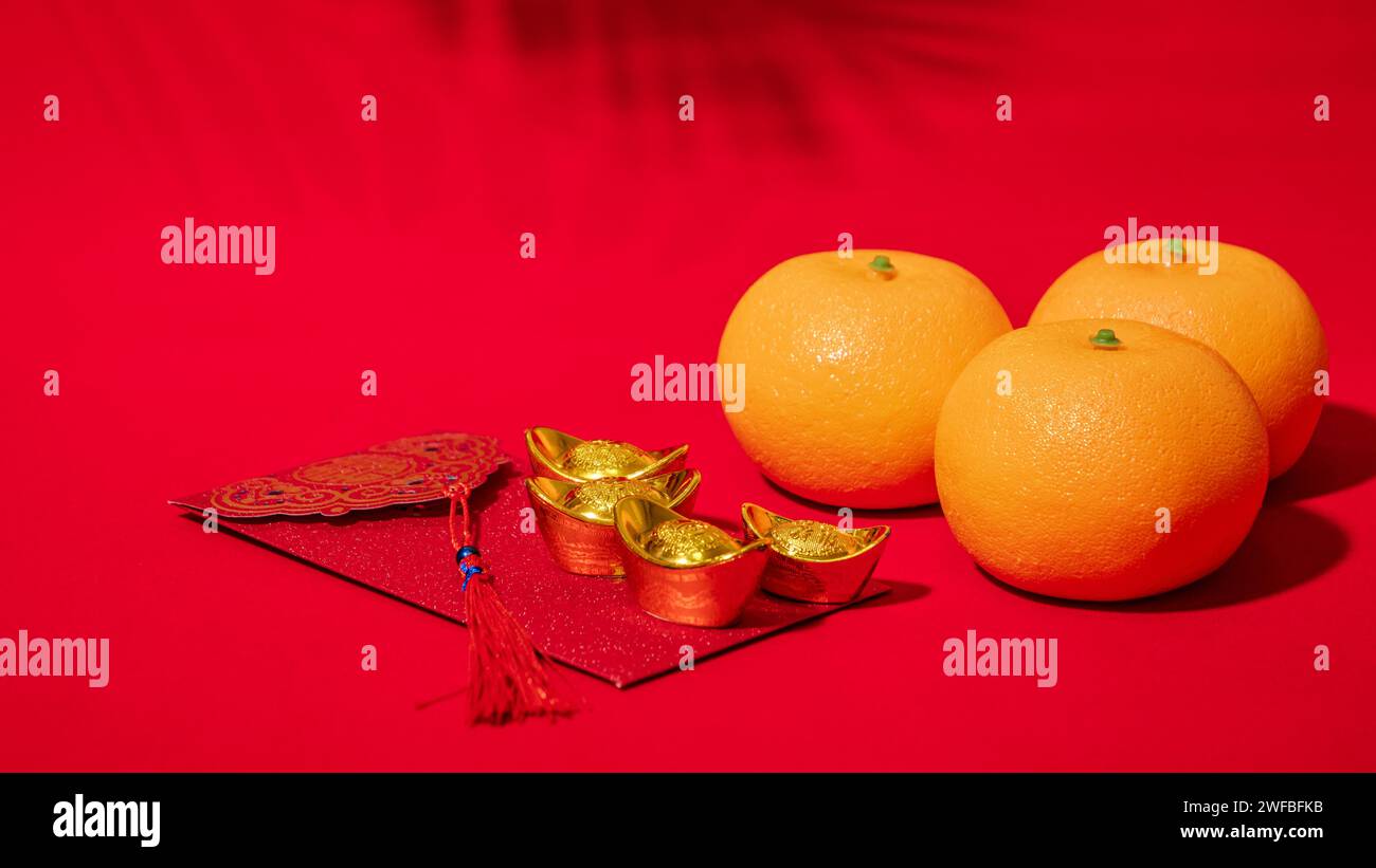 Chinese Lunar New Year red background. ancient Chinese gold bar, orange, red envelope, Tae Eia, ang pow, red packet for give money on Chinese new year Stock Photo