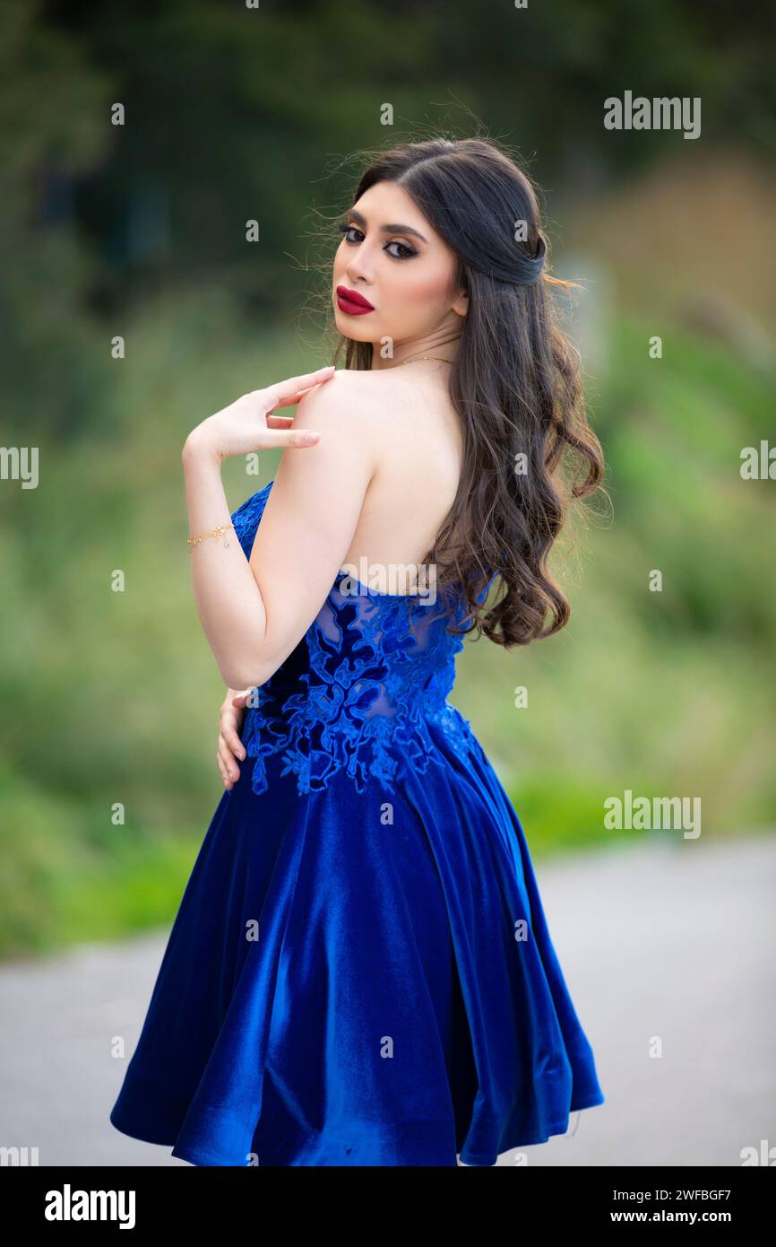 Beautiful elegant woman wearing blue evening dress looking over ...