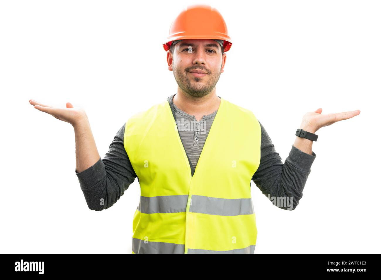 Friendly adult builder man wearing safety hardhat and yellow vest uniform holding palms as presenting blank copyspace for advertising text isolated on Stock Photo