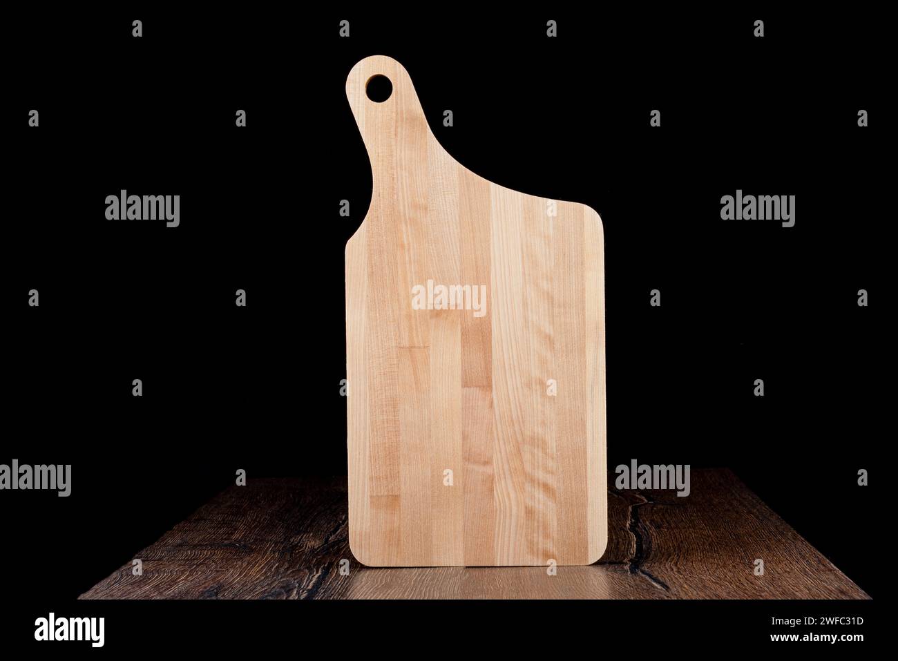 New wooden cutting board on a dark background. Copy space. Stock Photo