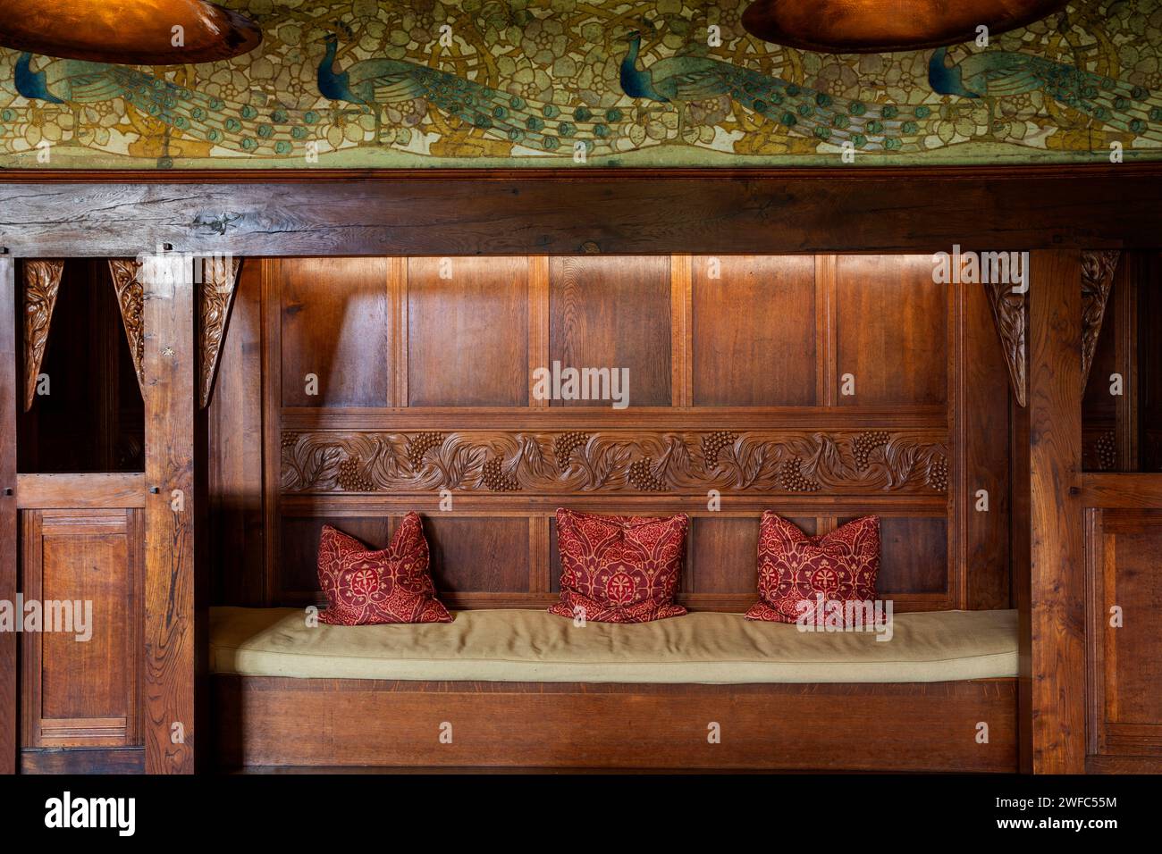 UK, Cumbria, Bowness on Windermere, Blackwell, Arts and Crafts House, Main Hall, Arthur Simpson of Kendal carved oak panelling frieze across settle Stock Photo