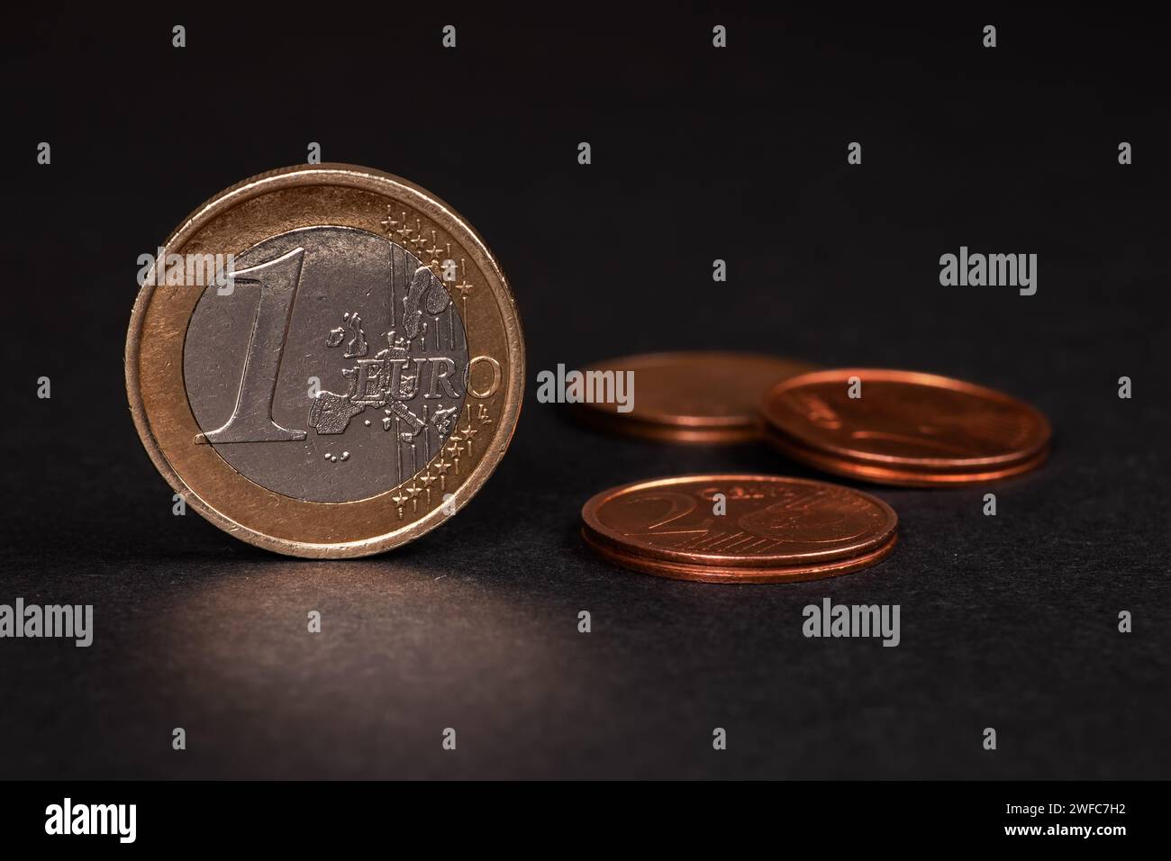 一ユーロ硬貨と背景にぼかされた硬貨たち