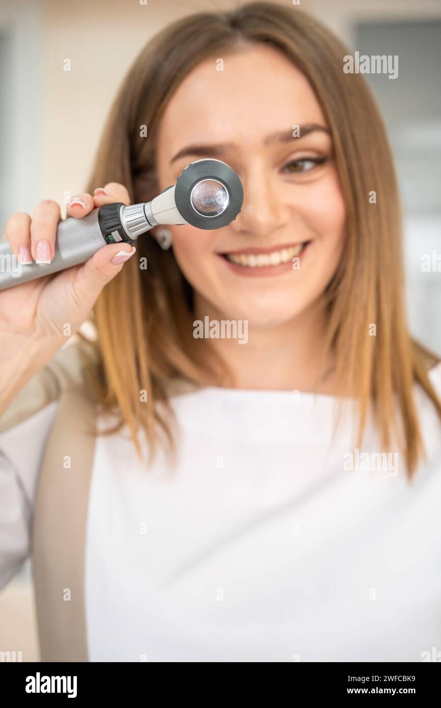 Portrait of young specialist dermatologist with dermatoscope in uniform