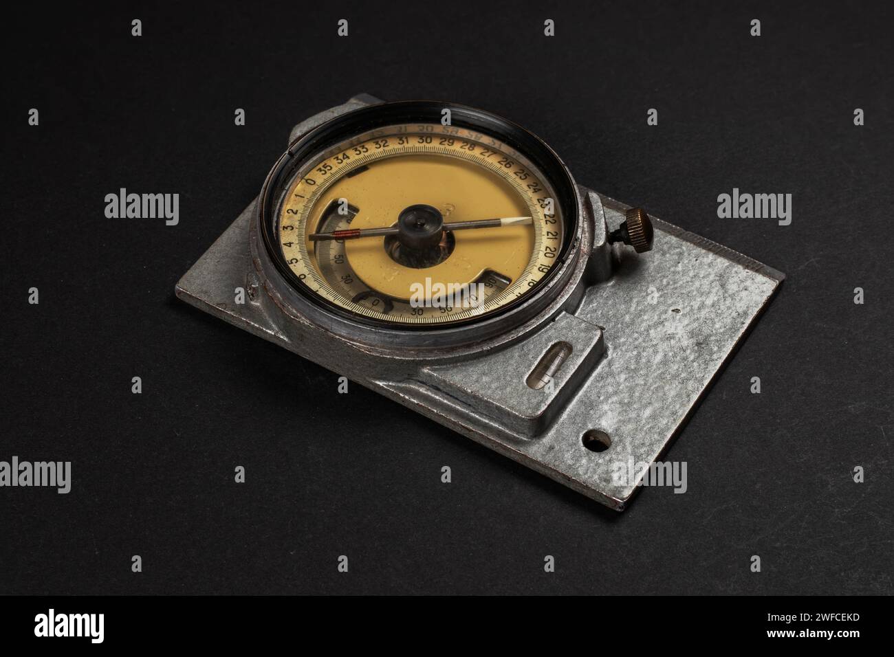 Old geological compass on dark background close up. Stock Photo