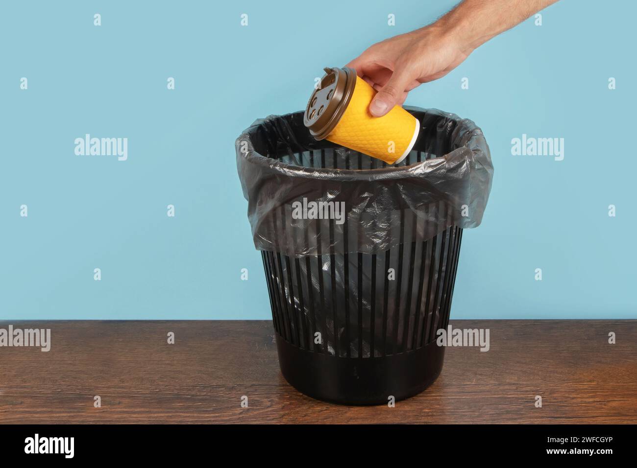 A hand throws a paper cup into the trash can Stock Photo - Alamy