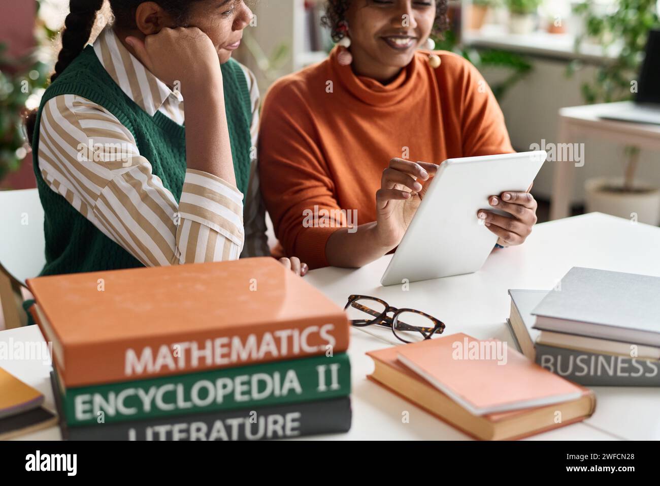 Closeup of two young African American girls using digital tablet together while studying in modern school classroom copy space Stock Photo