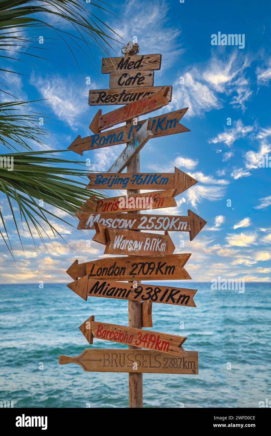 Hersonissos, Crete, Greece - July 23, 2021: Touristical and ornamental signs marking the direction and distance to famous cities in the world. Stock Photo