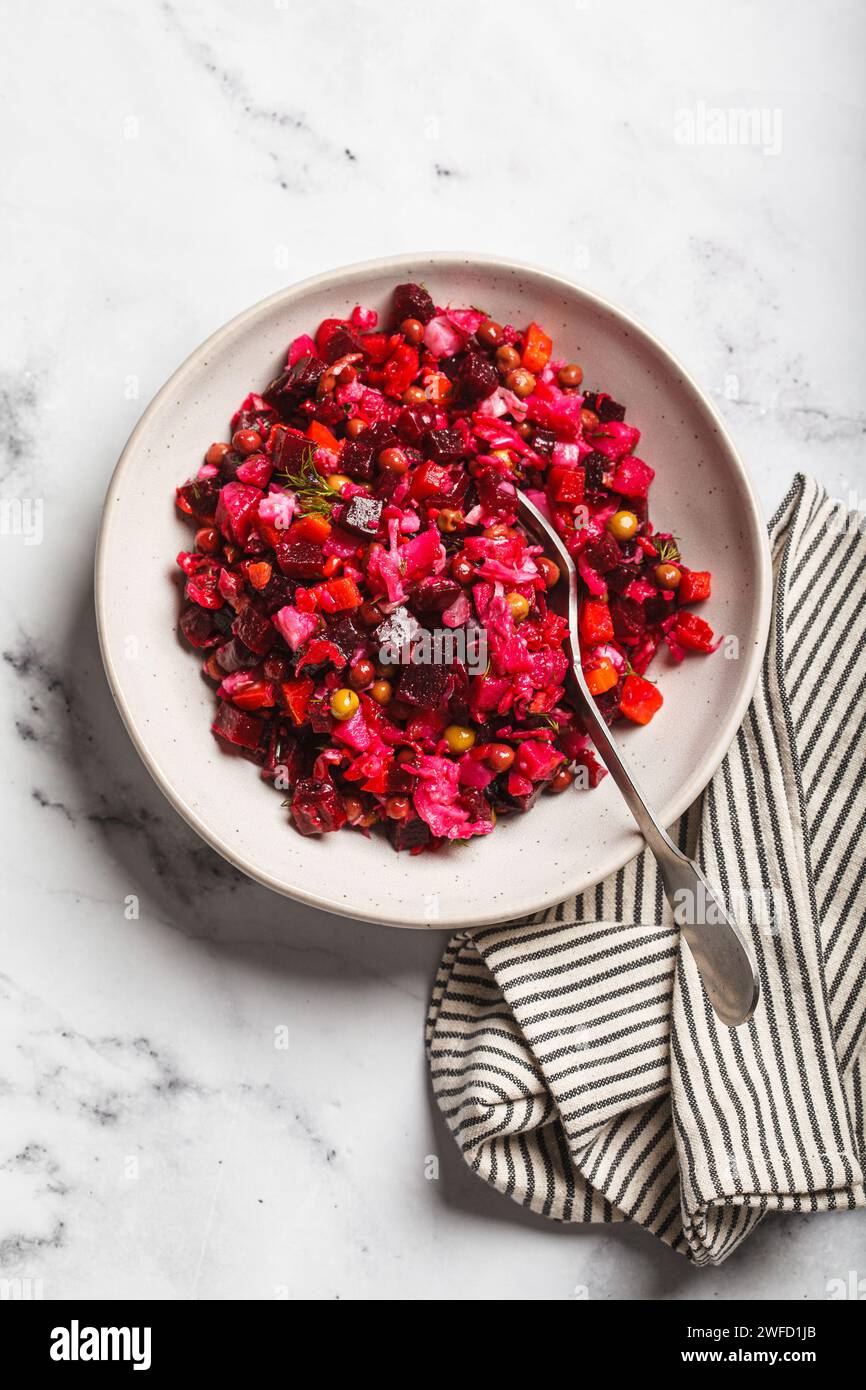 Russian beetroot vinaigrette salad with green peas, boiled vegetables and dill, top view. Stock Photo