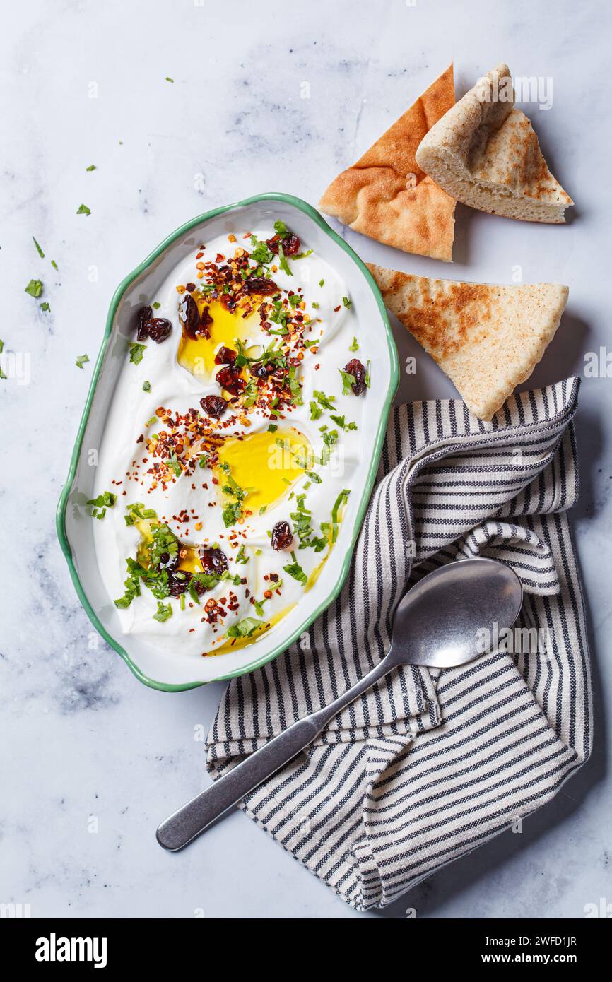 Whipped ricotta dip with chili, oil and cilantro, top view Stock Photo