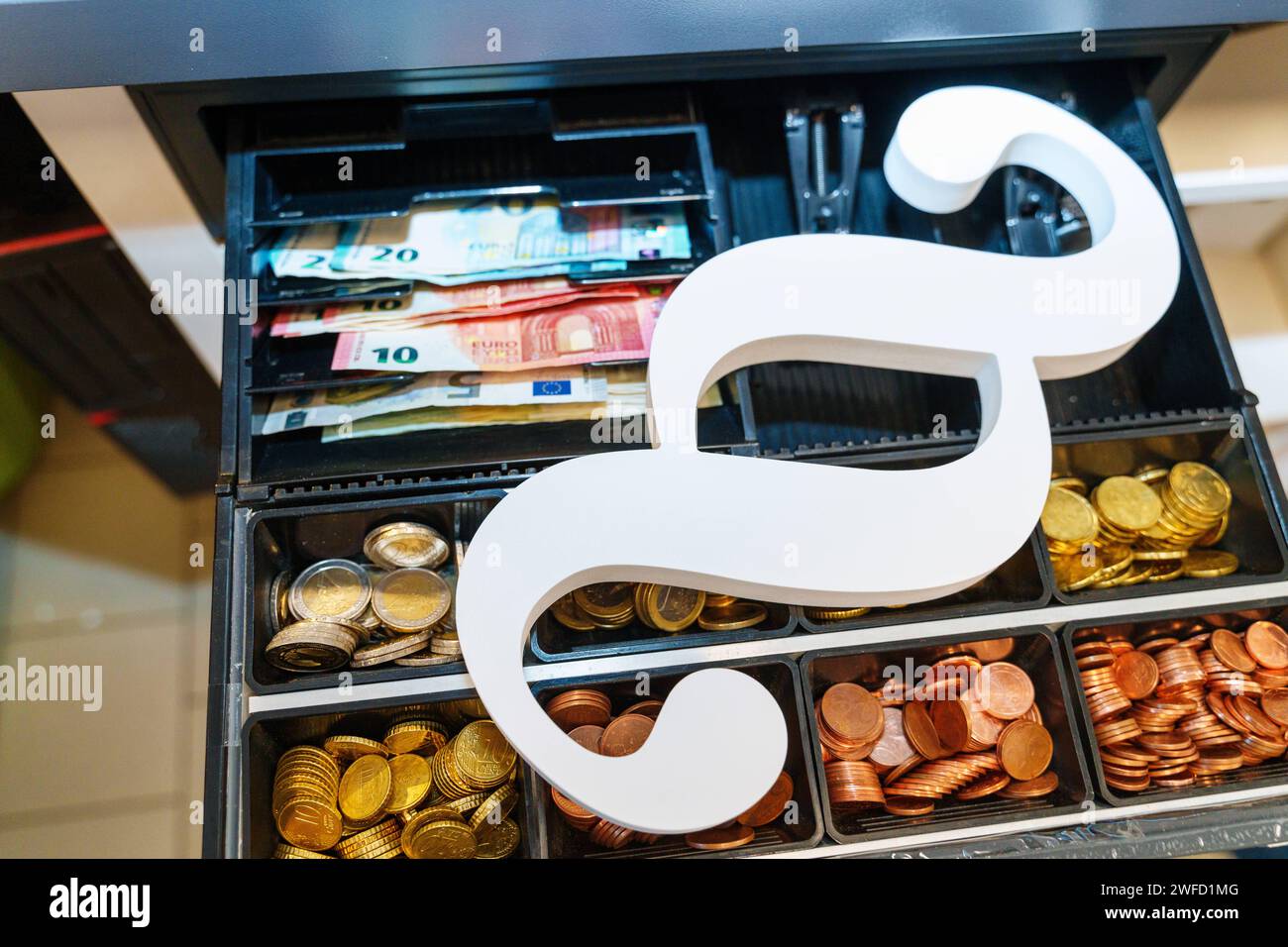 Augsburg, Bavaria, Germany - September 2, 2023: Paragraph symbol on an open cash register with euro cash bills and coins *** Paragrafen Symbol auf einer offenen Kasse mit Euro Bargeld Scheinen und Münzen Stock Photo