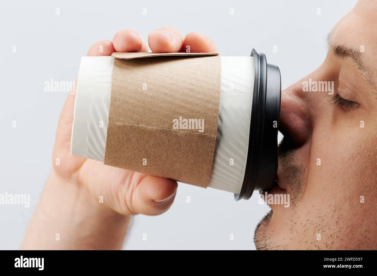 Man drink from paper cup side view close up isolated on white studio ...
