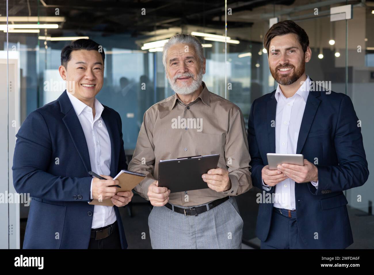 Three Professionals Collaborating Three diverse professional businessmen smiling and standing together in ...
