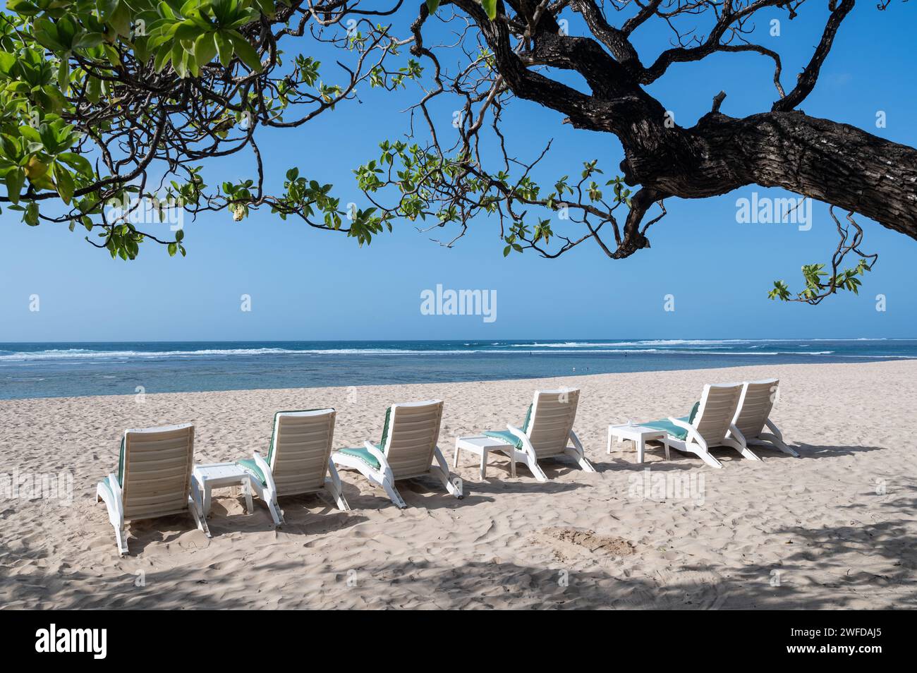 25.07.2023, Nusa Dua, Benoa, Bali, Indonesia, Asia - Empty tropical sandy beach with beach chairs on the beach at Nusa Dua with a view of the sea. Stock Photo