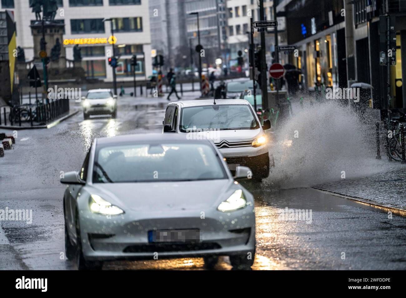 Winter, rainy weather, freezing rain, large puddle, puddle of water, in the city center, Große Gallusstraße, vehicles driving through, spraying water Stock Photo