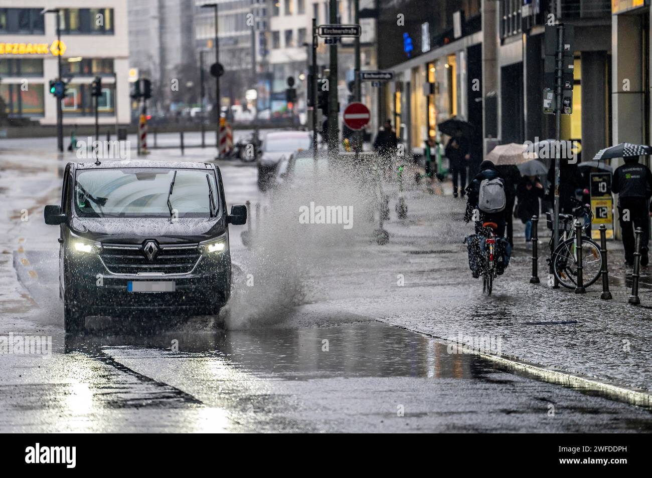 Winter, rainy weather, freezing rain, large puddle, puddle of water, in the city center, Große Gallusstraße, vehicles driving through, spraying water Stock Photo