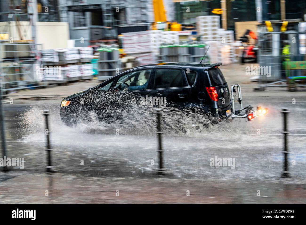 Winter, rainy weather, freezing rain, large puddle, puddle of water, in the city center, Große Gallusstraße, vehicles driving through, spraying water Stock Photo