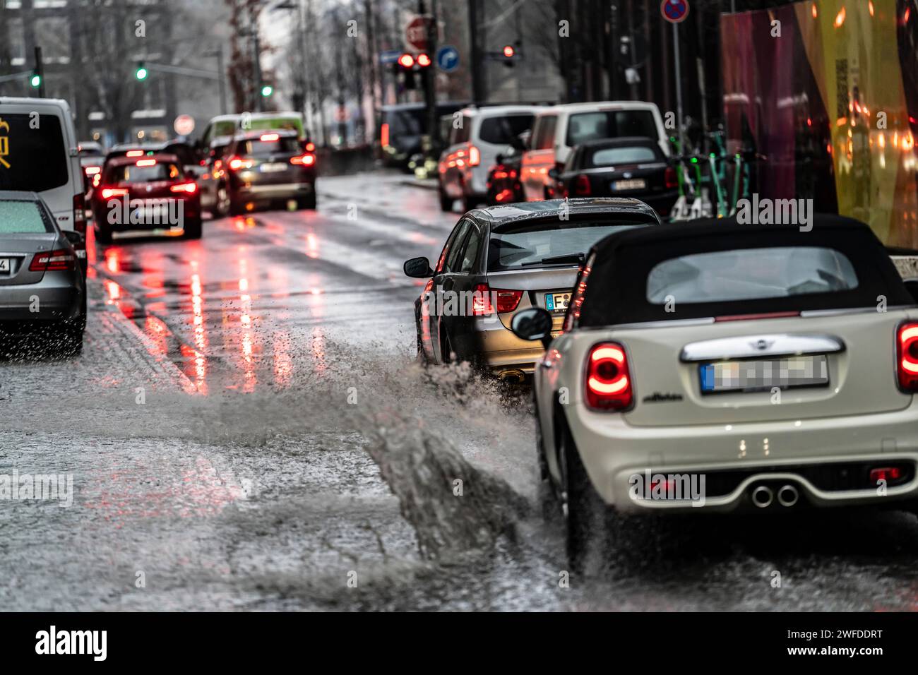 Winter, rainy weather, freezing rain, large puddle, puddle of water, in the city center, Große Gallusstraße, vehicles driving through, spraying water Stock Photo