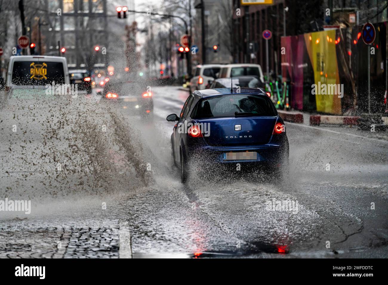 Winter, rainy weather, freezing rain, large puddle, puddle of water, in the city center, Große Gallusstraße, vehicles driving through, spraying water Stock Photo