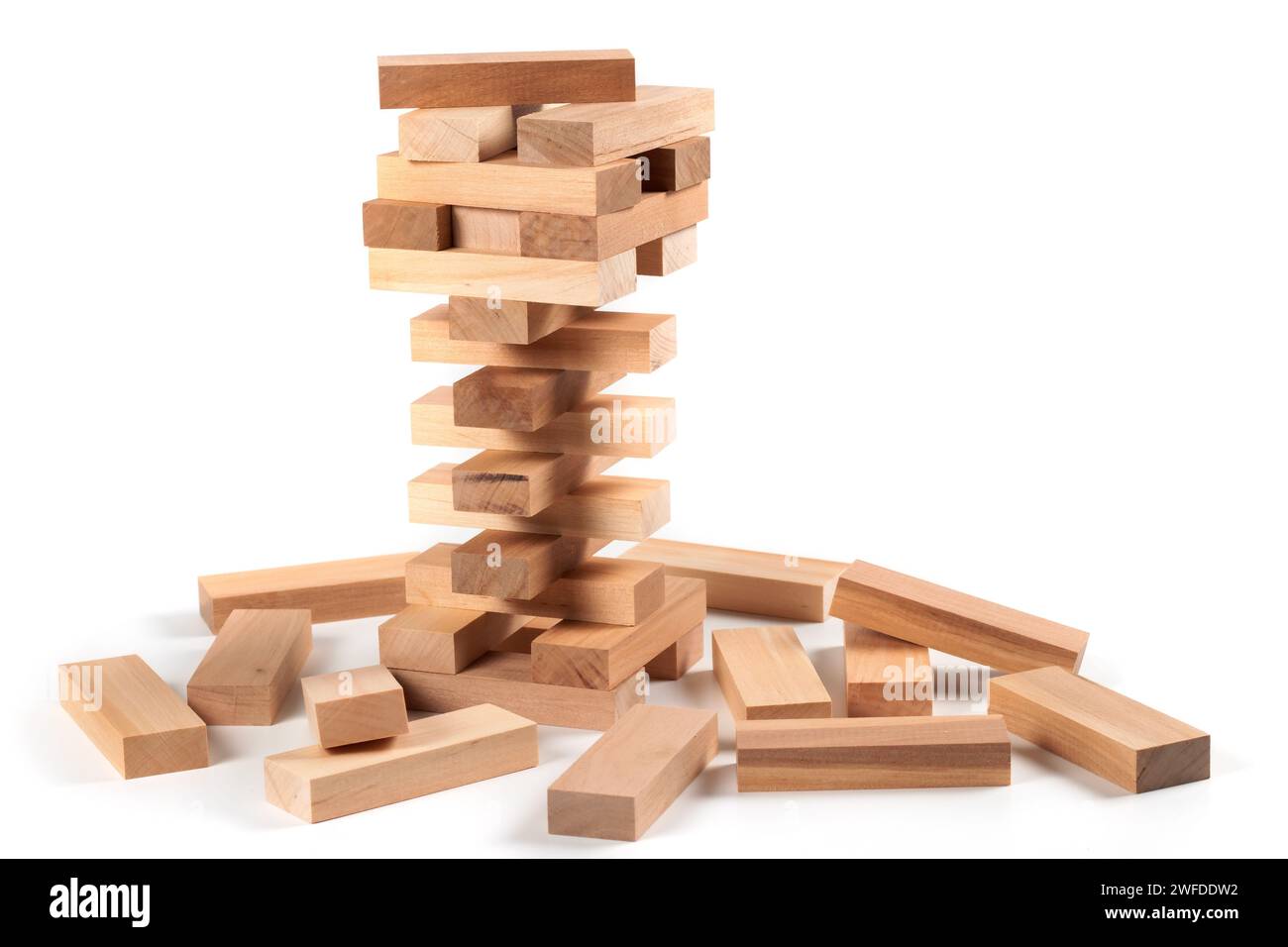 A game of logic and the ability to think. Jenga tower with wooden blocks on a white background. The tower is half dismantled Stock Photo