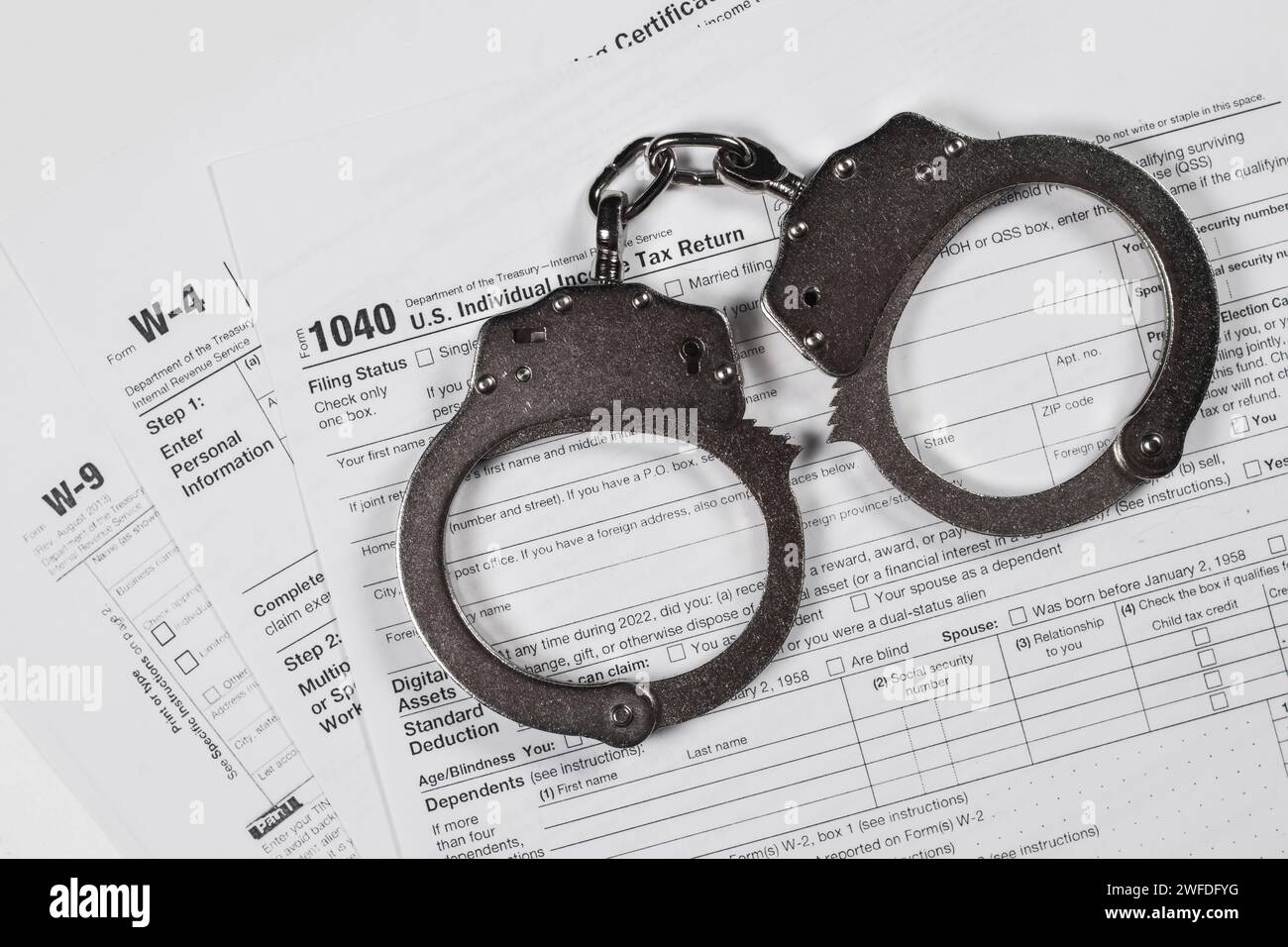 Income tax return documents and handcuffs tax evasion crime and fraud