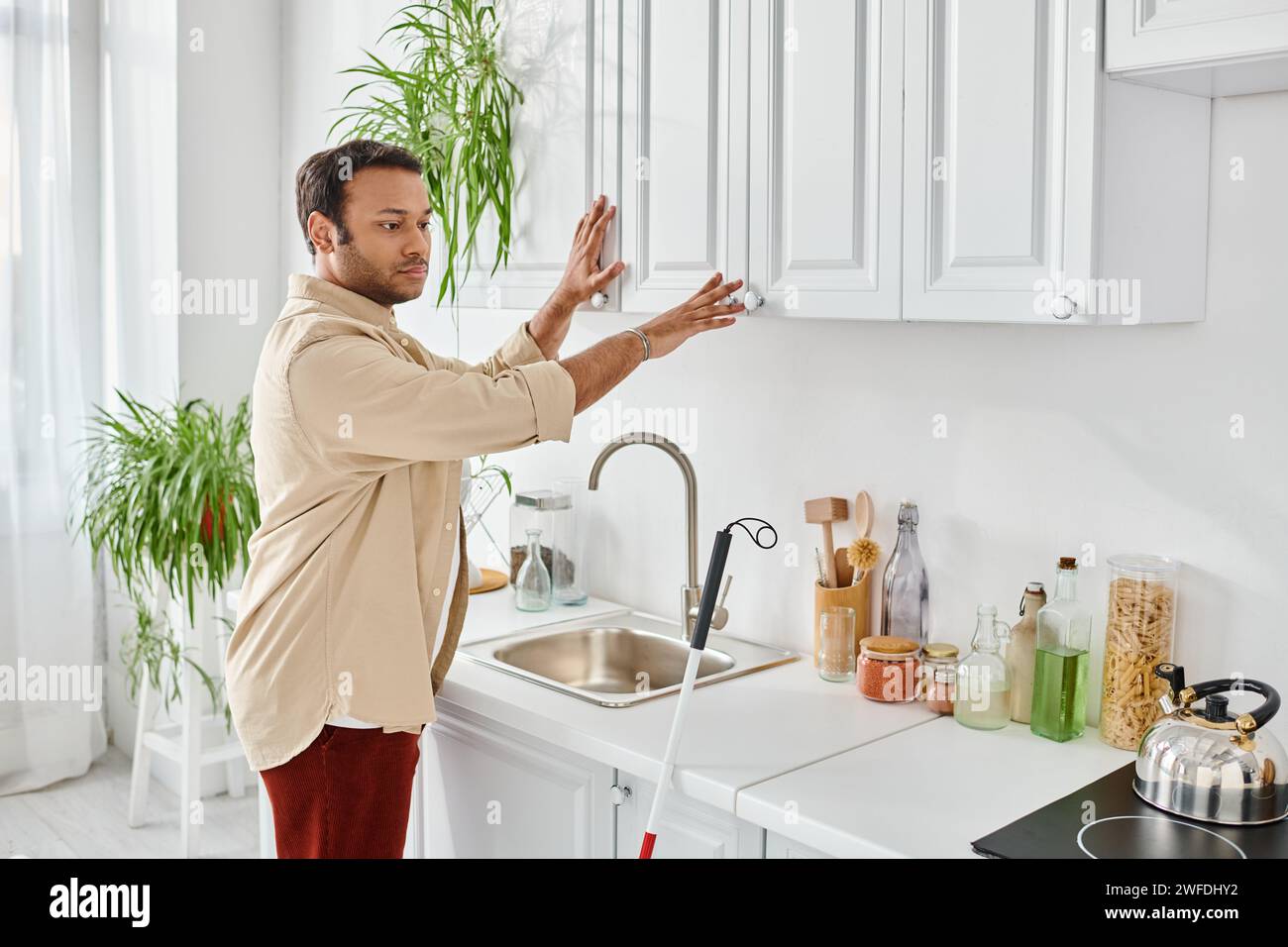 handsome indian man with visual impairment in comfortable homewear and preparing food, disabled Stock Photo