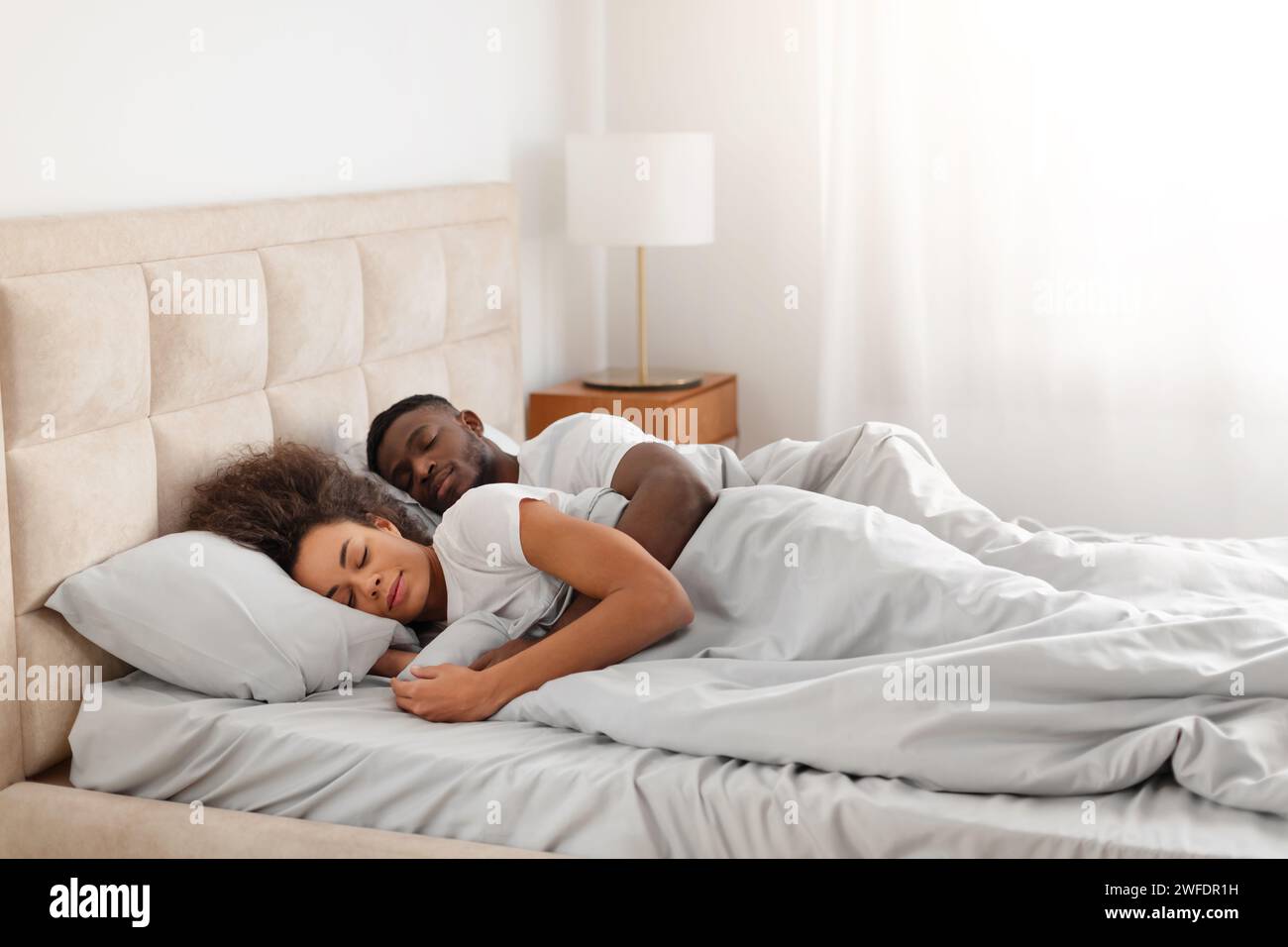 Calm african american husband hugging wife while sleeping together ...