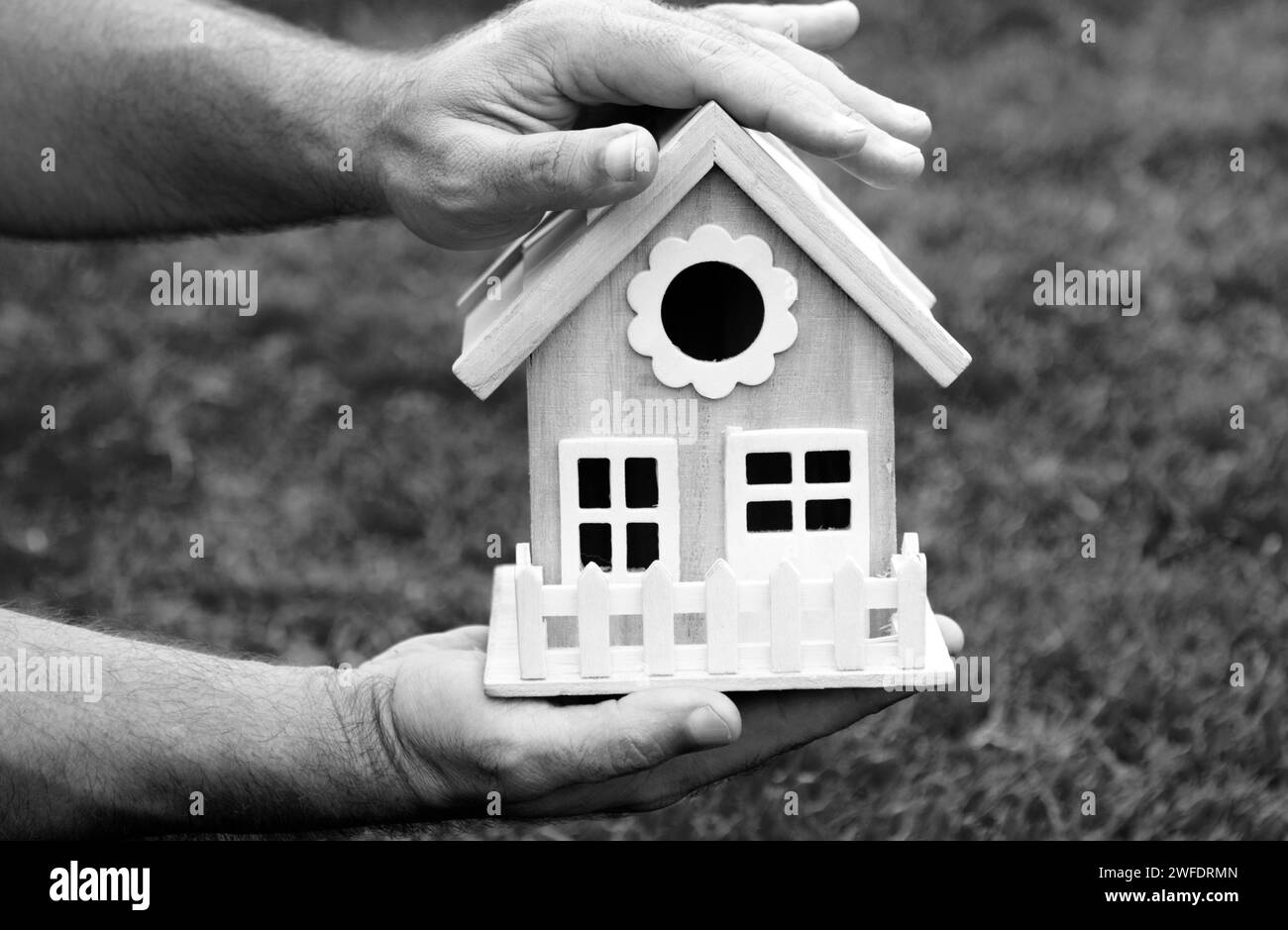 Protect your house concept. Hand holding house representing home ownership and the real estate. Stock Photo