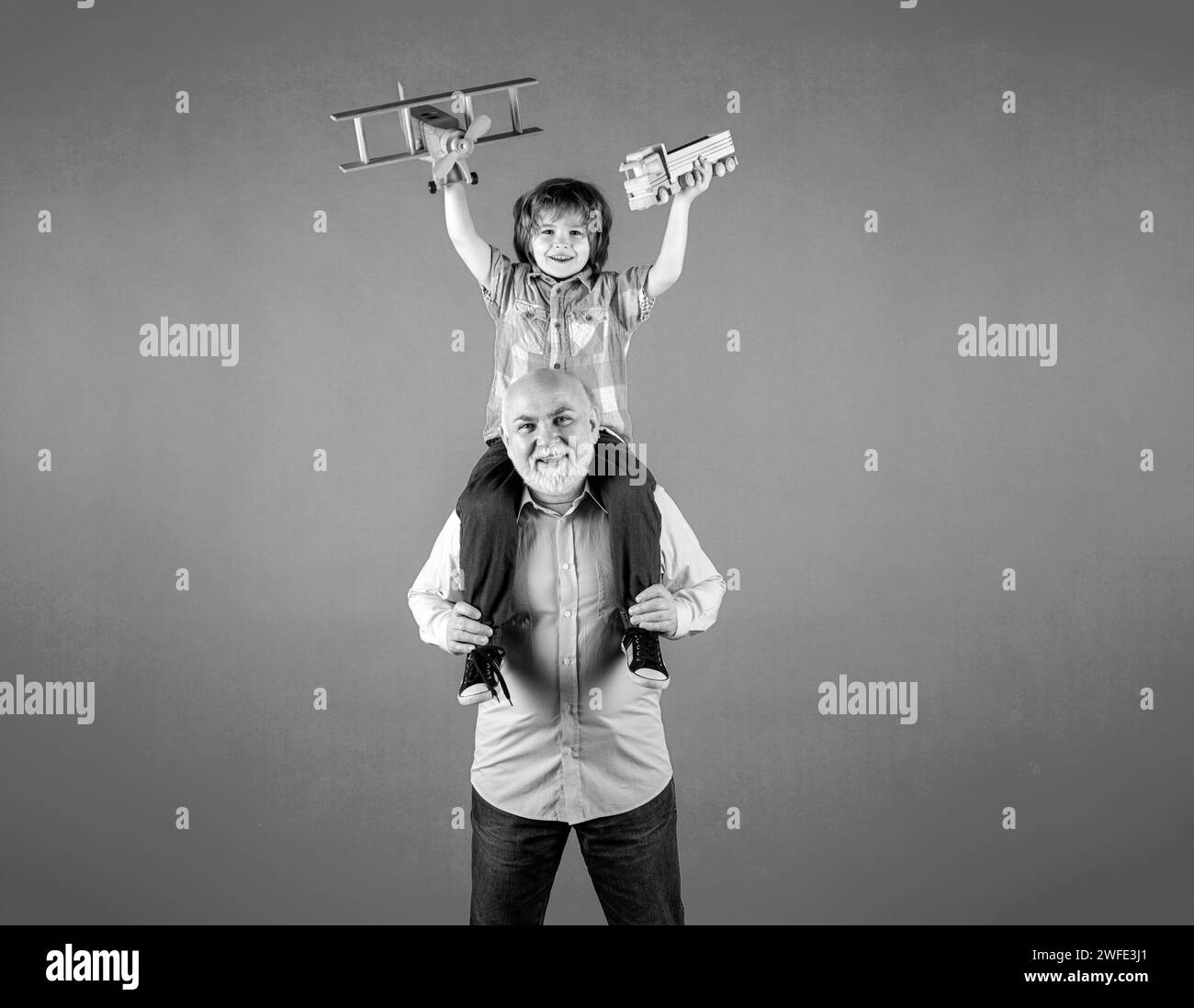Child boy and grandfather with toy plane and wooden toy truck. Men