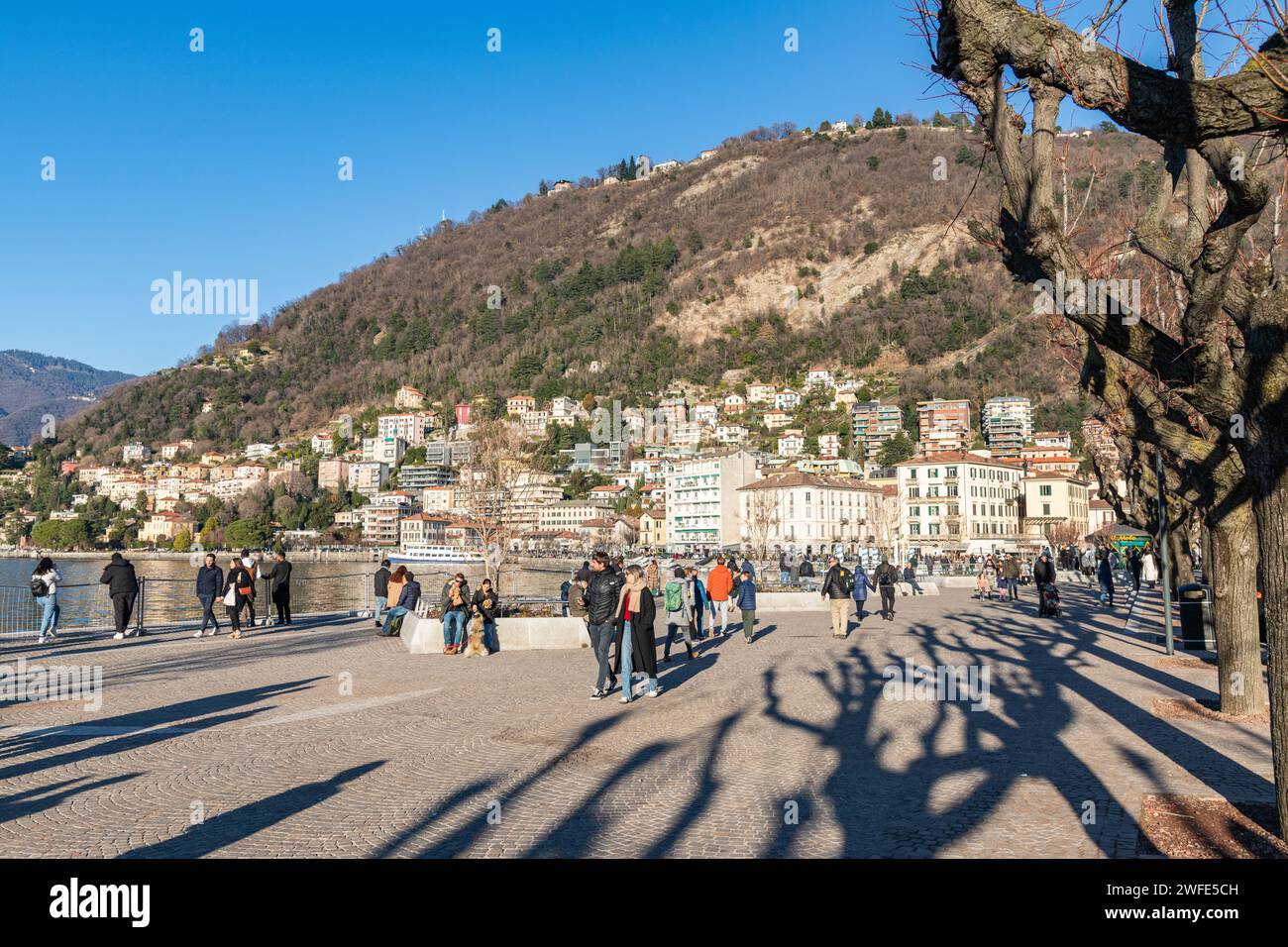 People / Tourists walking along a promenade by Lake Como in Como, Italy Stock Photo