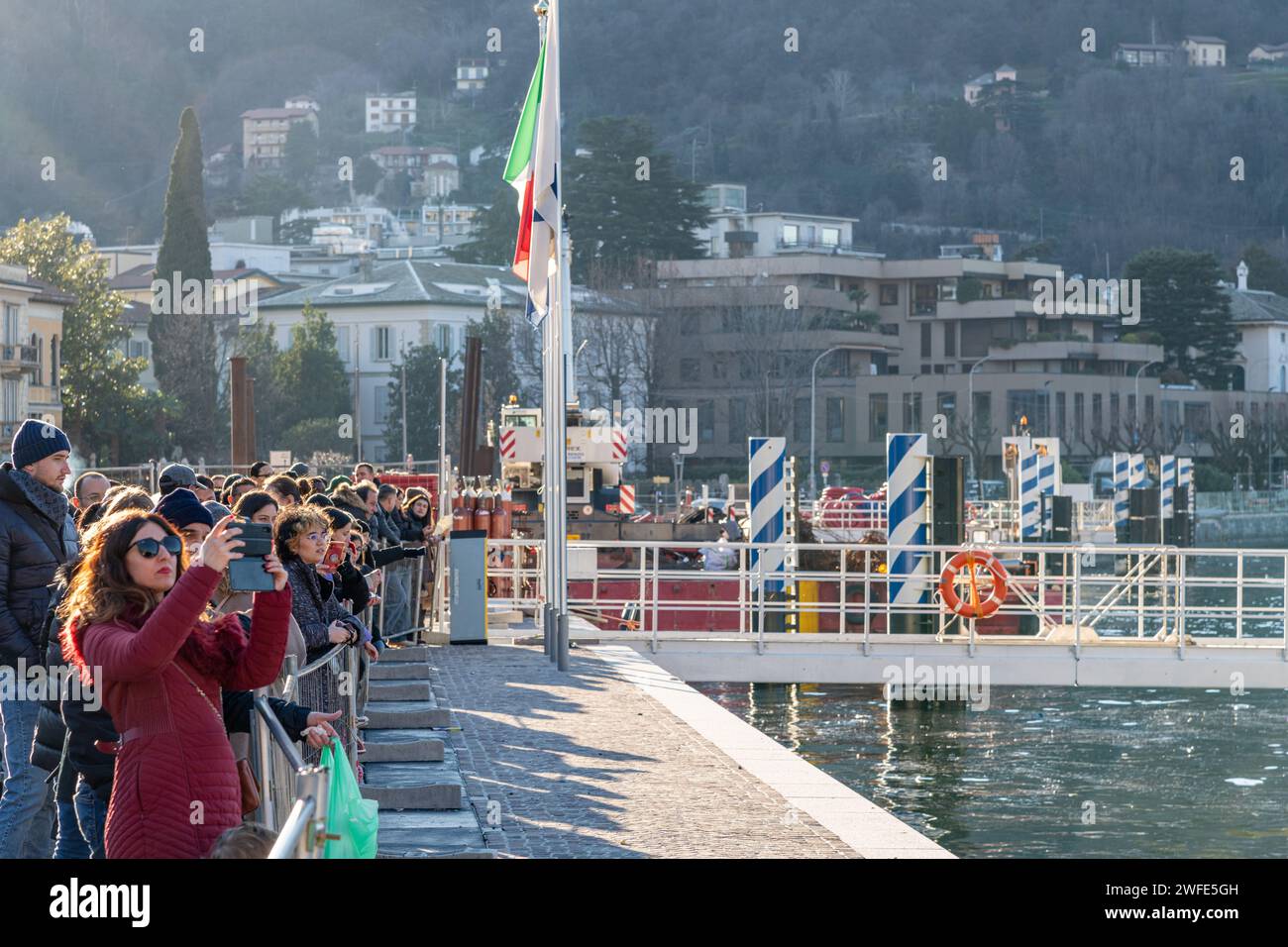A crowd of people / tourists taking photos and looking at Lake Como in Como, Italy Stock Photo