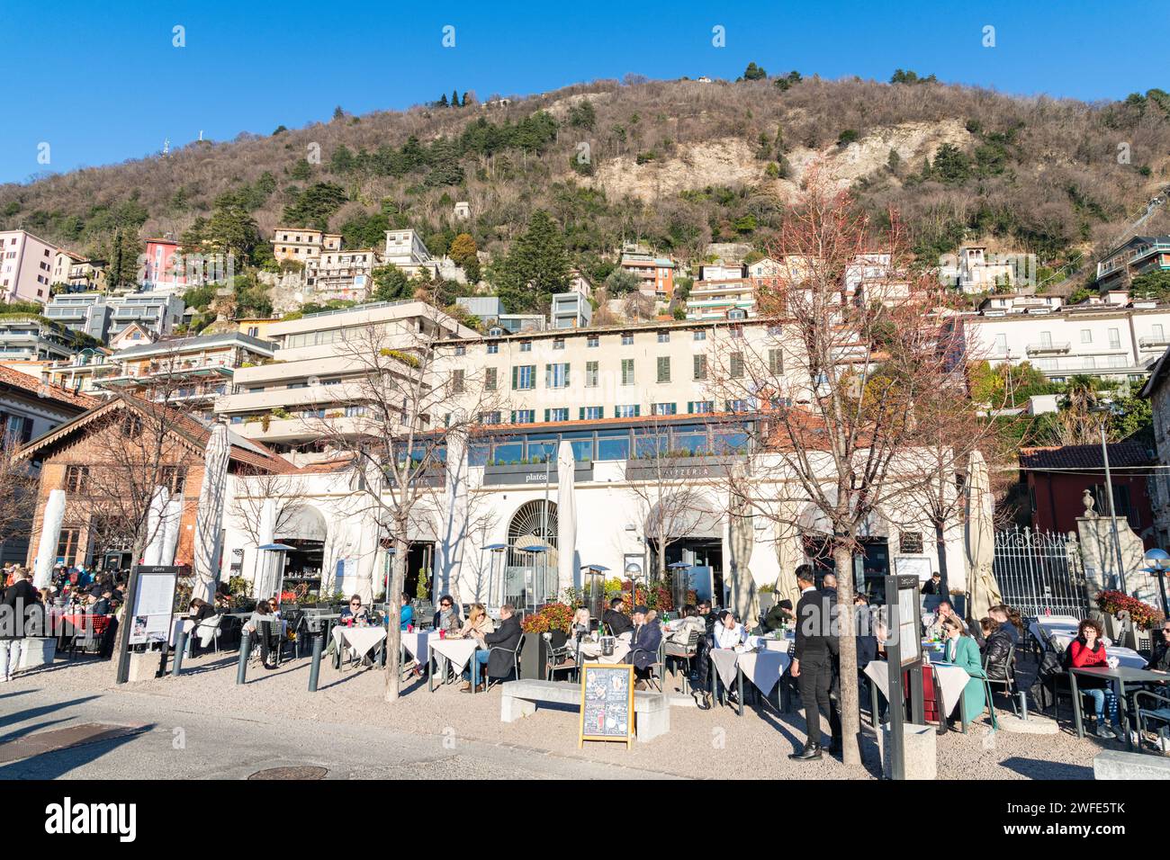 People sitting and dining at a cafe / restaurant / bar by Lake Como in Italy Stock Photo